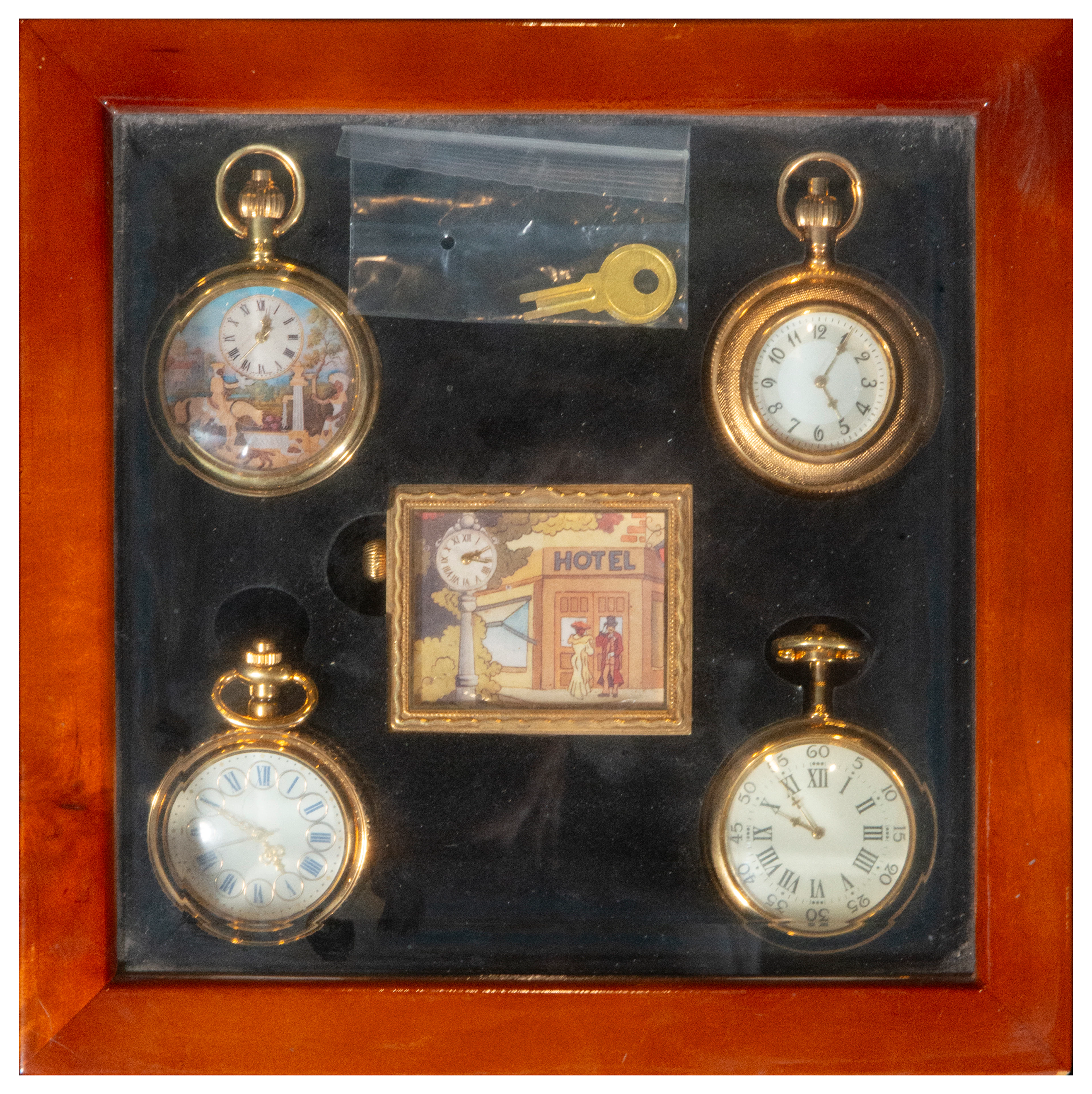 Set of four pocket watches in a wooden display case