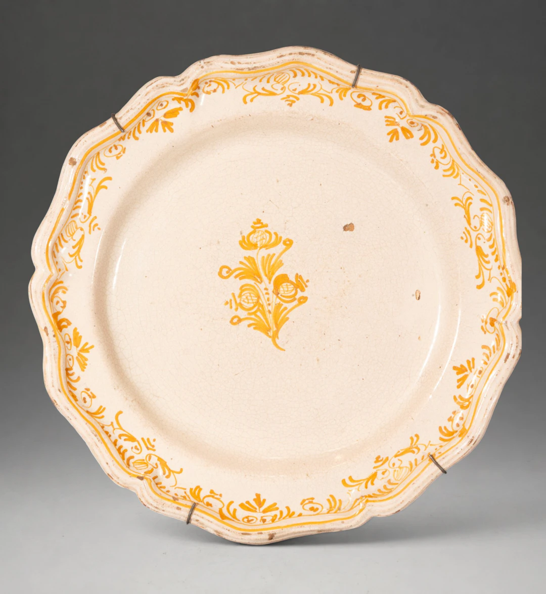 MANISES CERAMICS - Plate with wavy rim and floral decoration in ochre yellow
