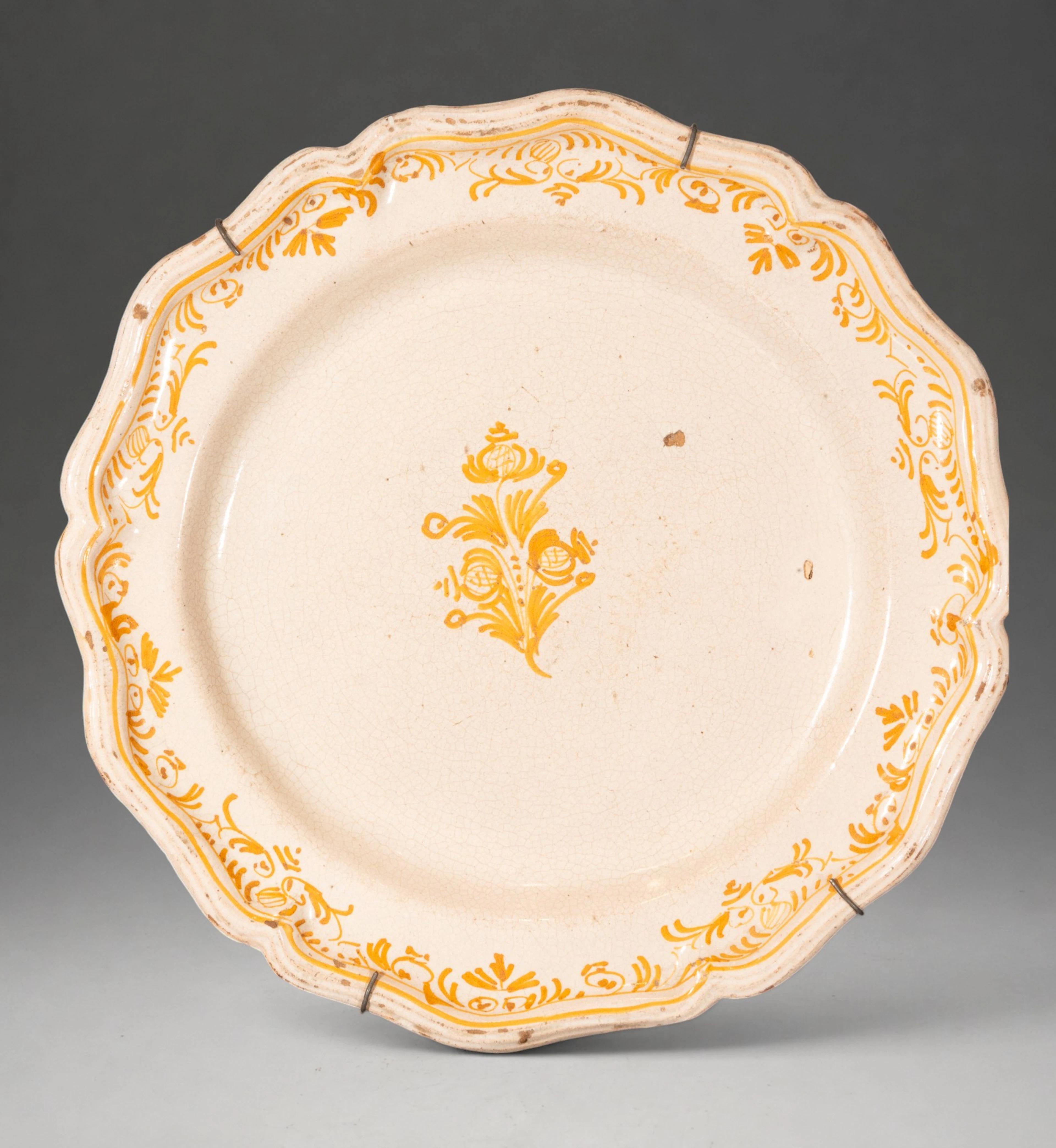 MANISES CERAMICS - Plate with wavy rim and floral decoration in ochre yellow