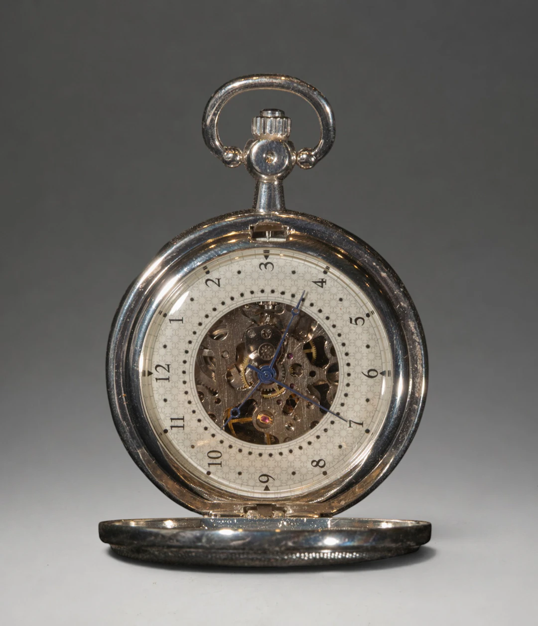 Pocket watch with central medallion and visible mechanism