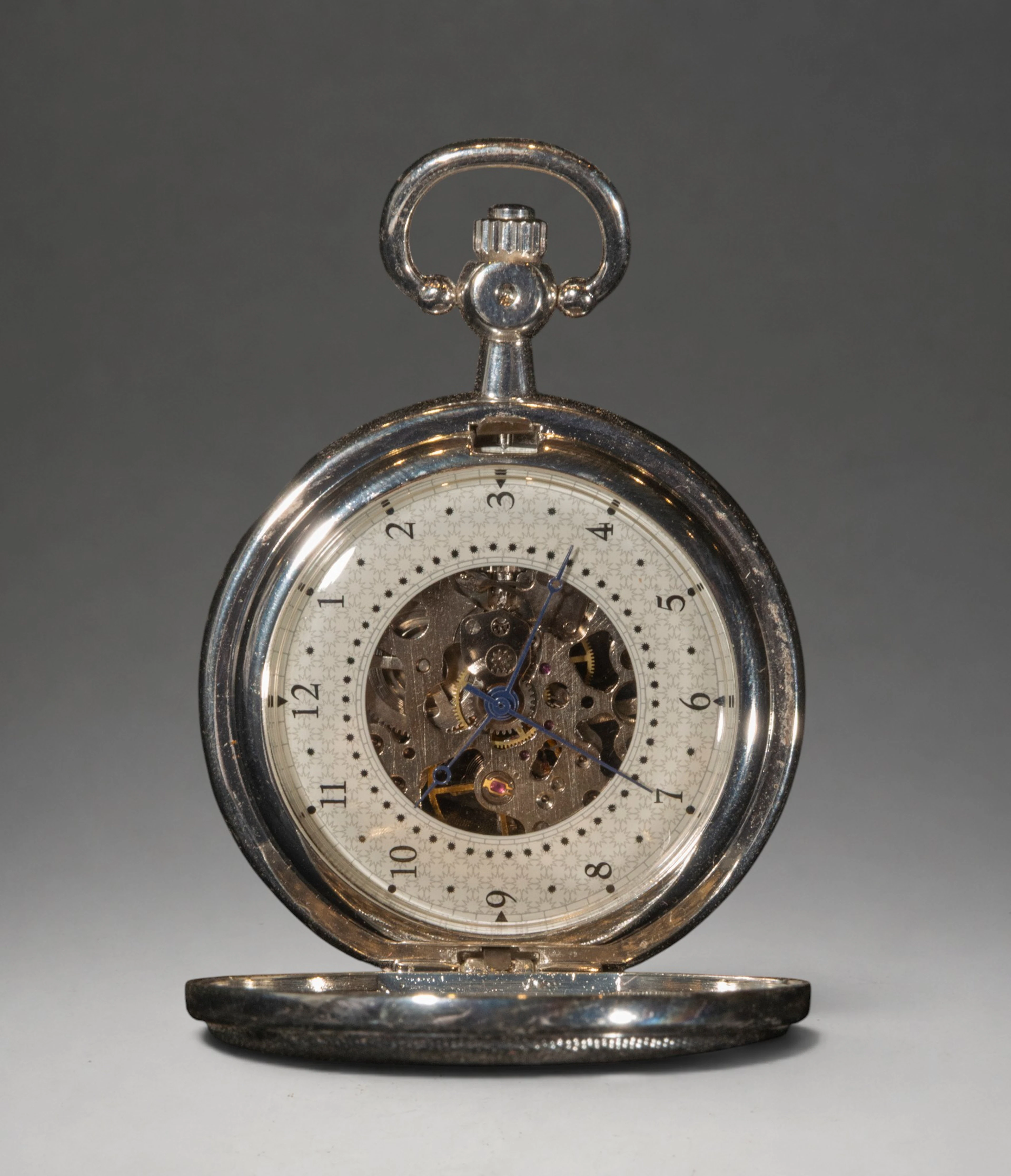 Pocket watch with central medallion and visible mechanism