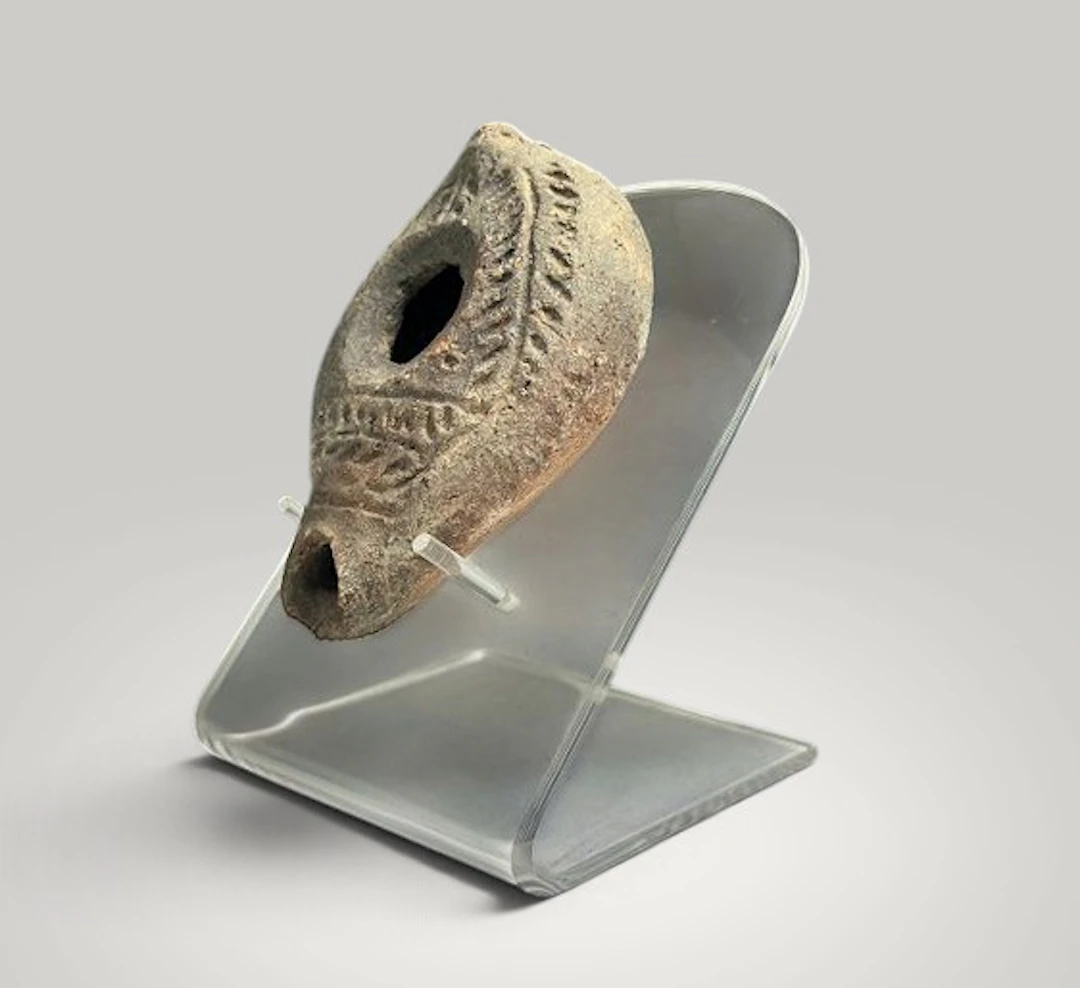Oil lamp decorated with plant motifs.