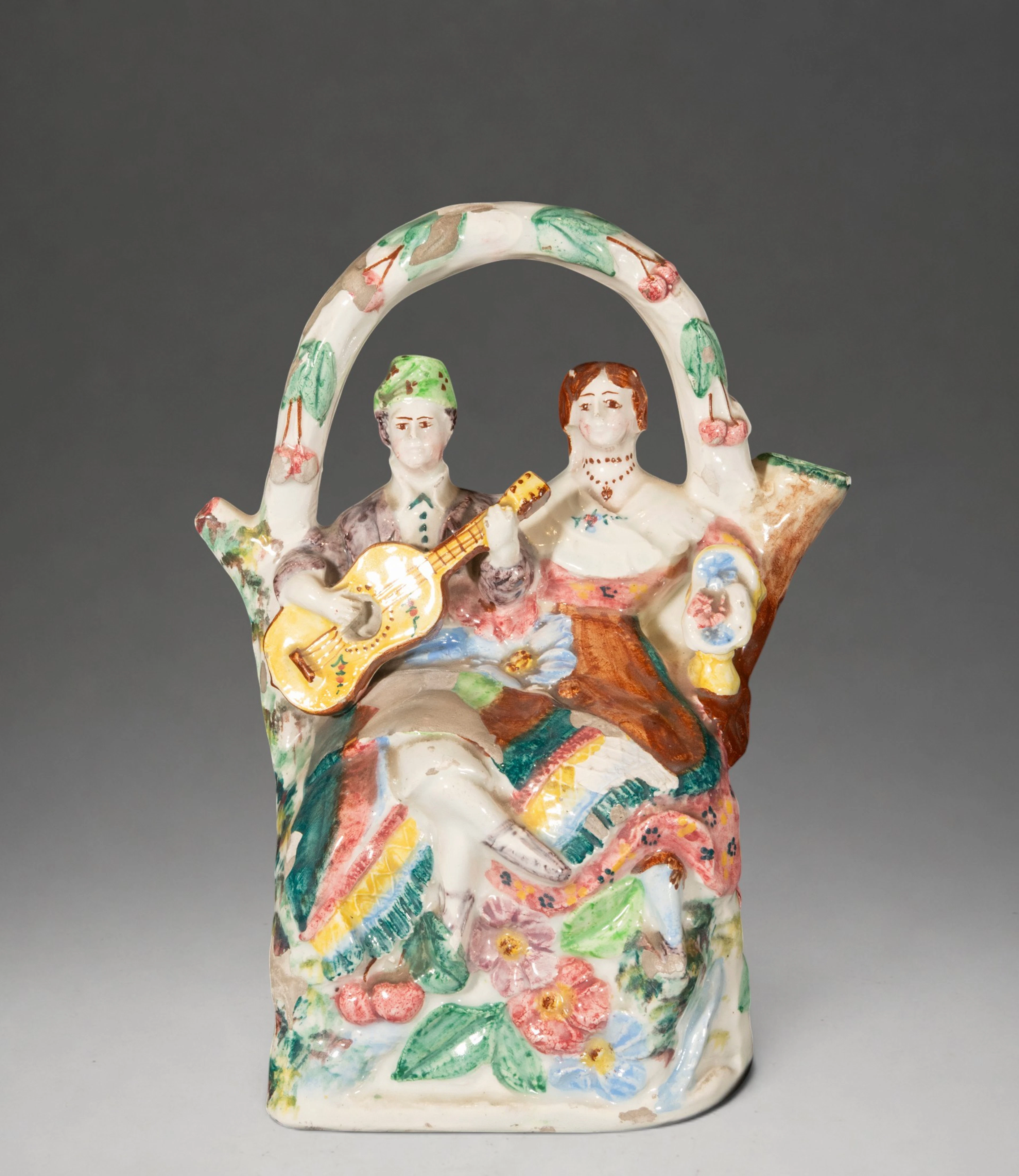 Figurative water jug ​​with a pair of musicians and polychrome floral