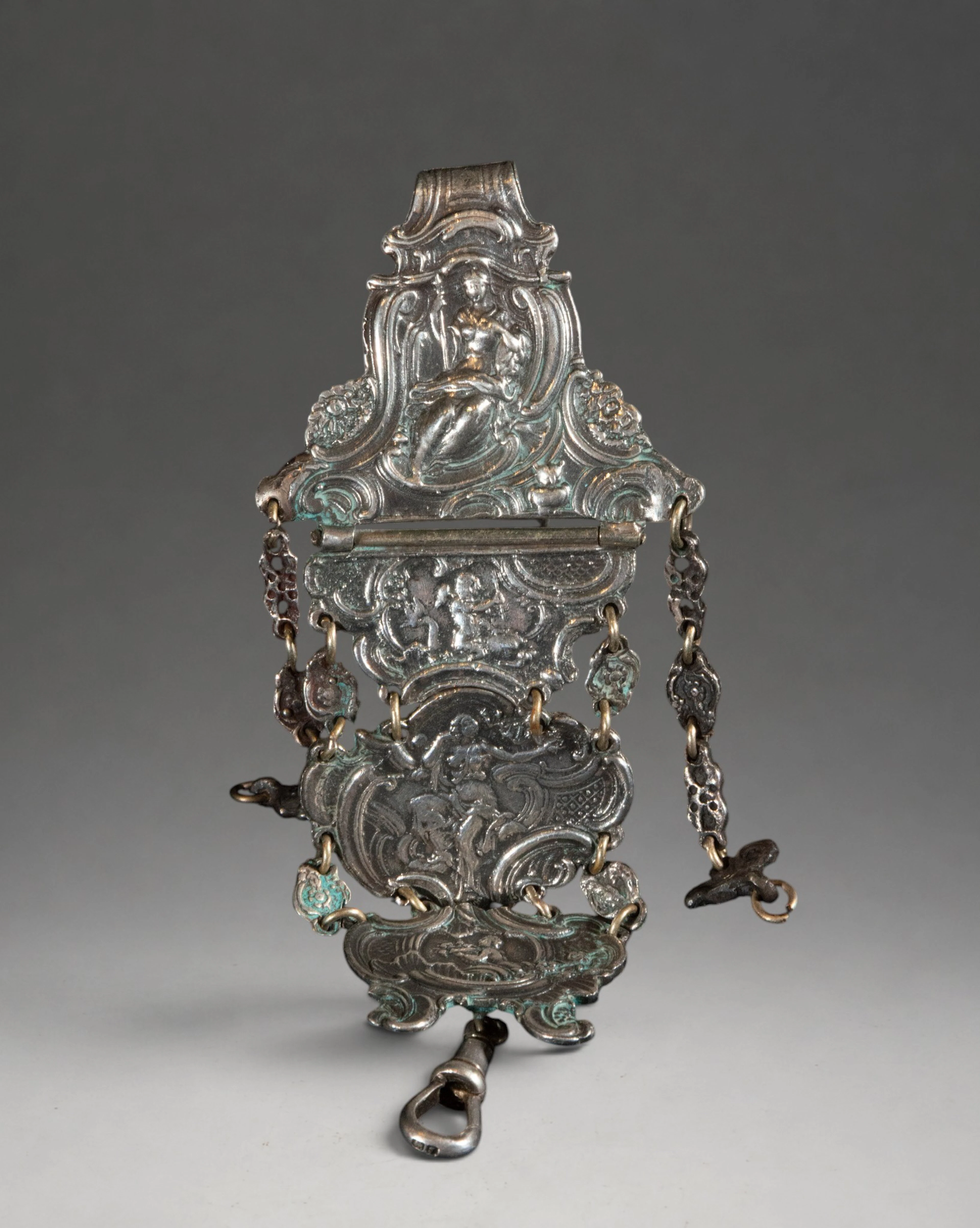Articulated ornamental piece of silver-plated metal with figures and cherubs