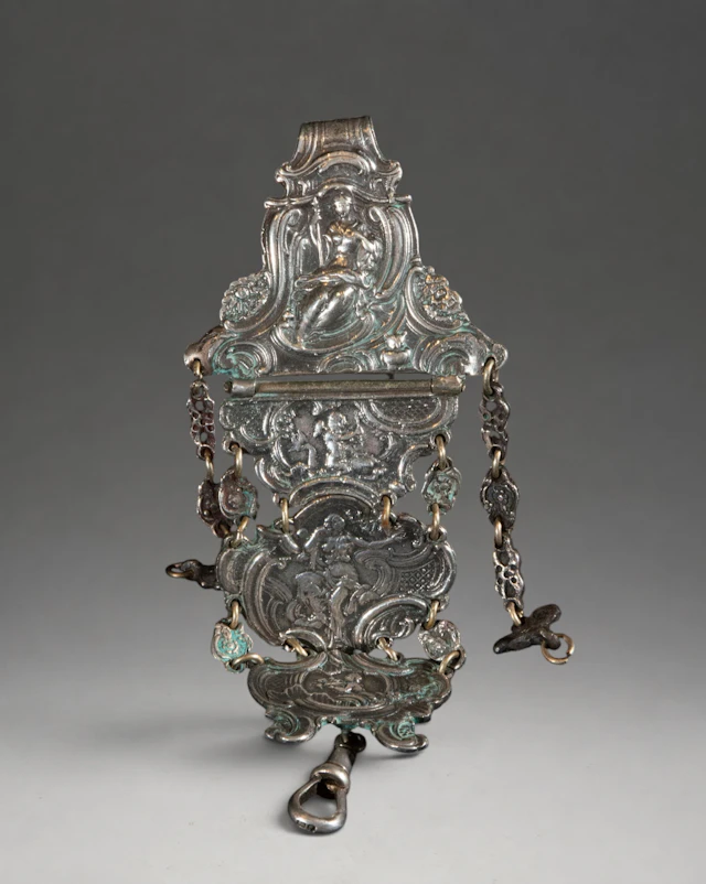 Articulated ornamental piece of silver-plated metal with figures and cherubs
