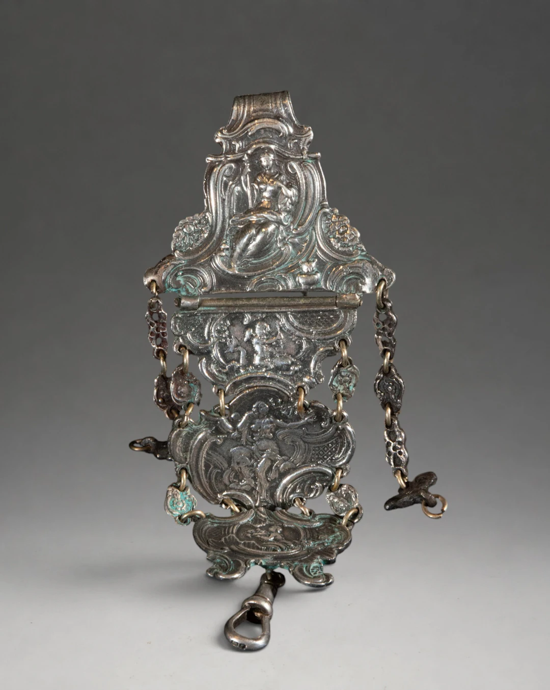 Articulated ornamental piece of silver-plated metal with figures and cherubs