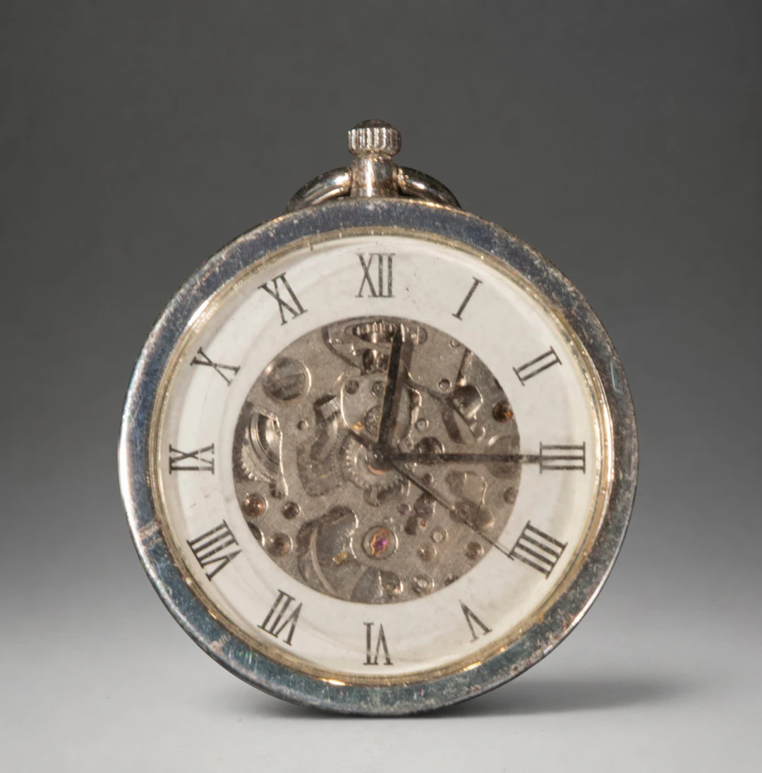 Pocket watch with visible movement dial and Roman numerals