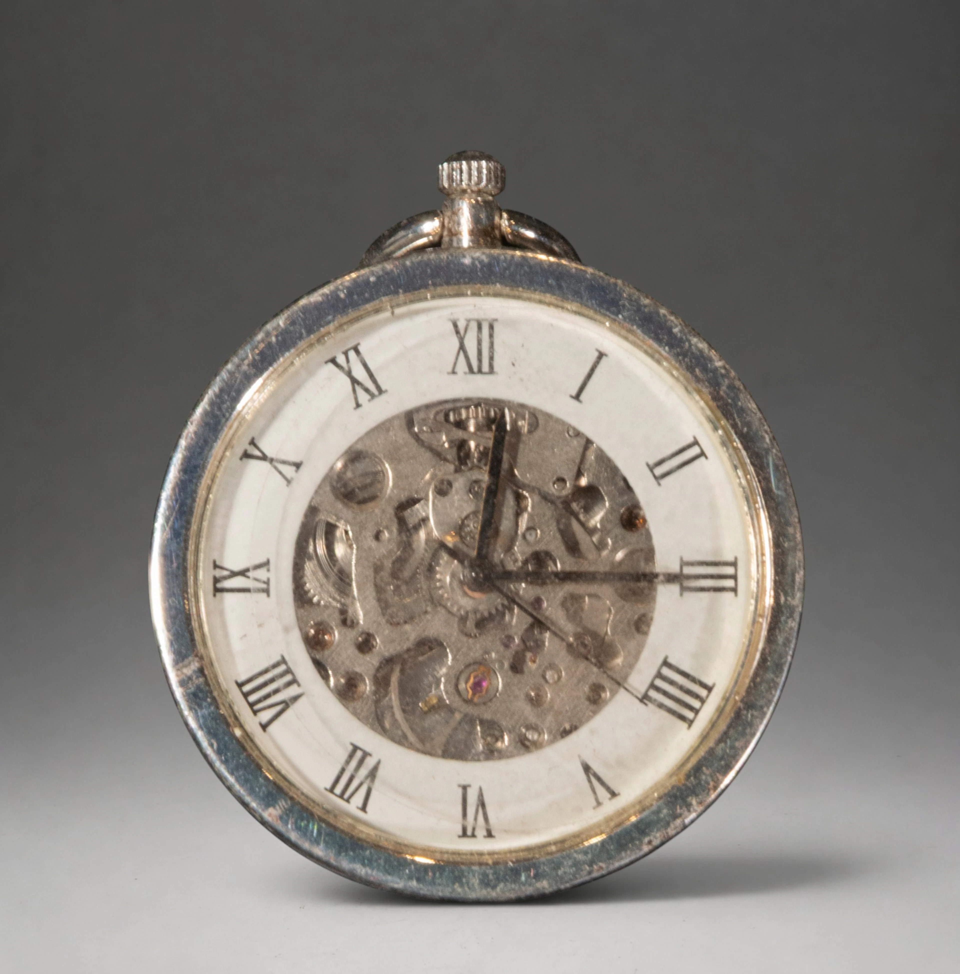 Pocket watch with visible movement dial and Roman numerals
