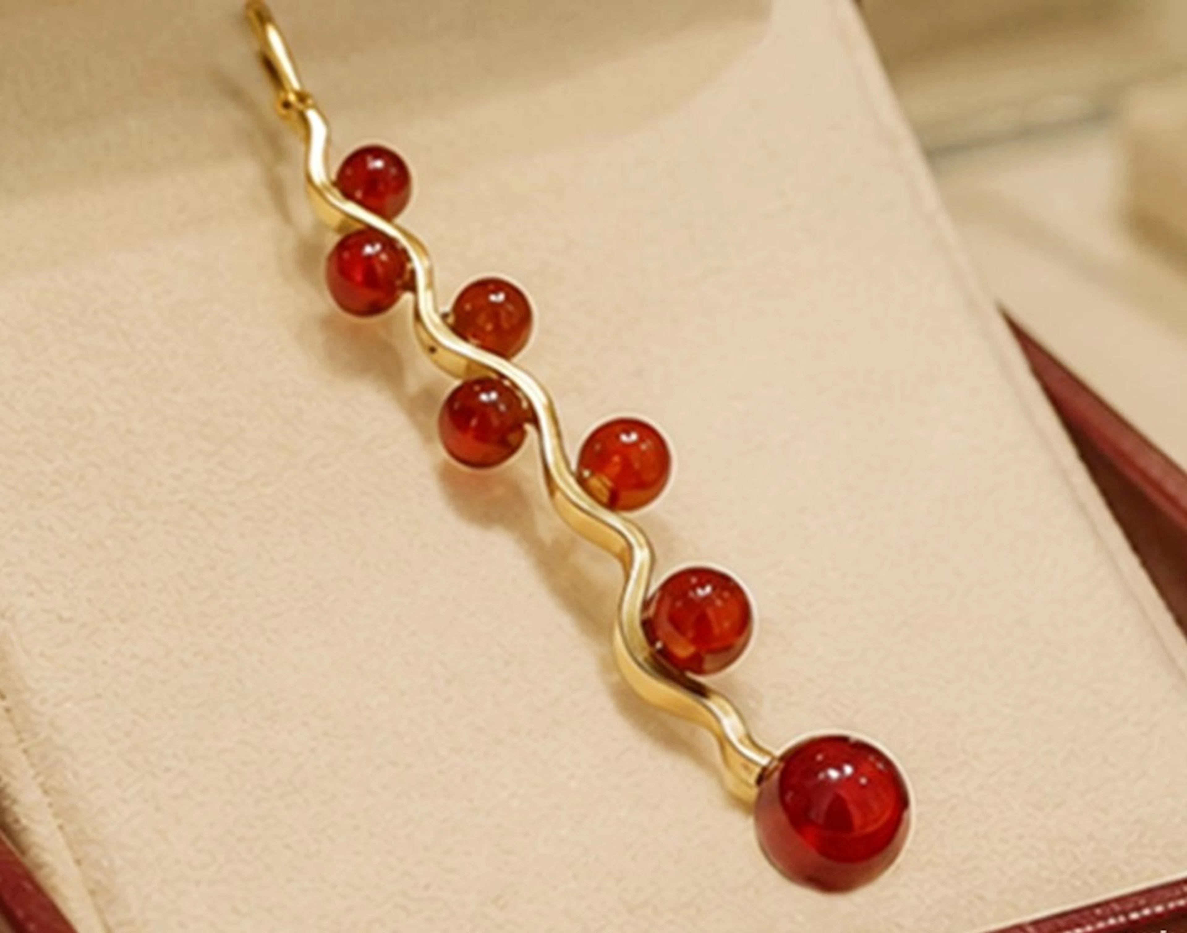Large long pendant in 18-karat gold with seven natural garnets. 20th century.