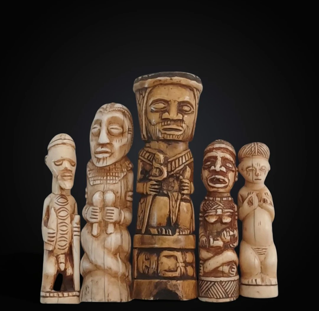 Group of five figures carved from warthog bone, representing tribal