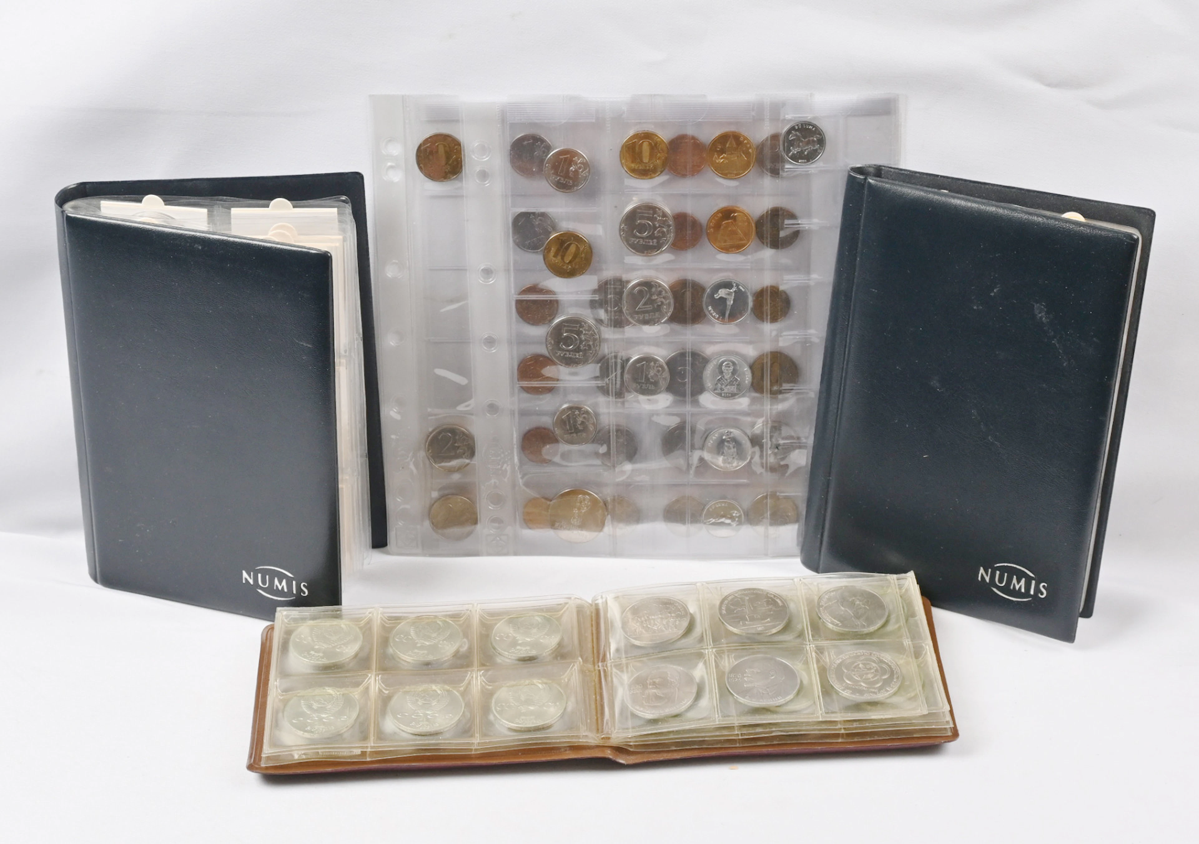 Selection of coins and tokens in three small albums etc. Three ”St