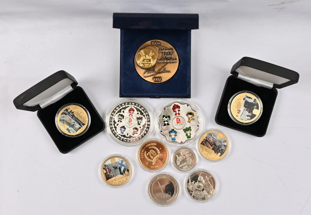 Olympics-themed coins and medals small selection in a wooden coin