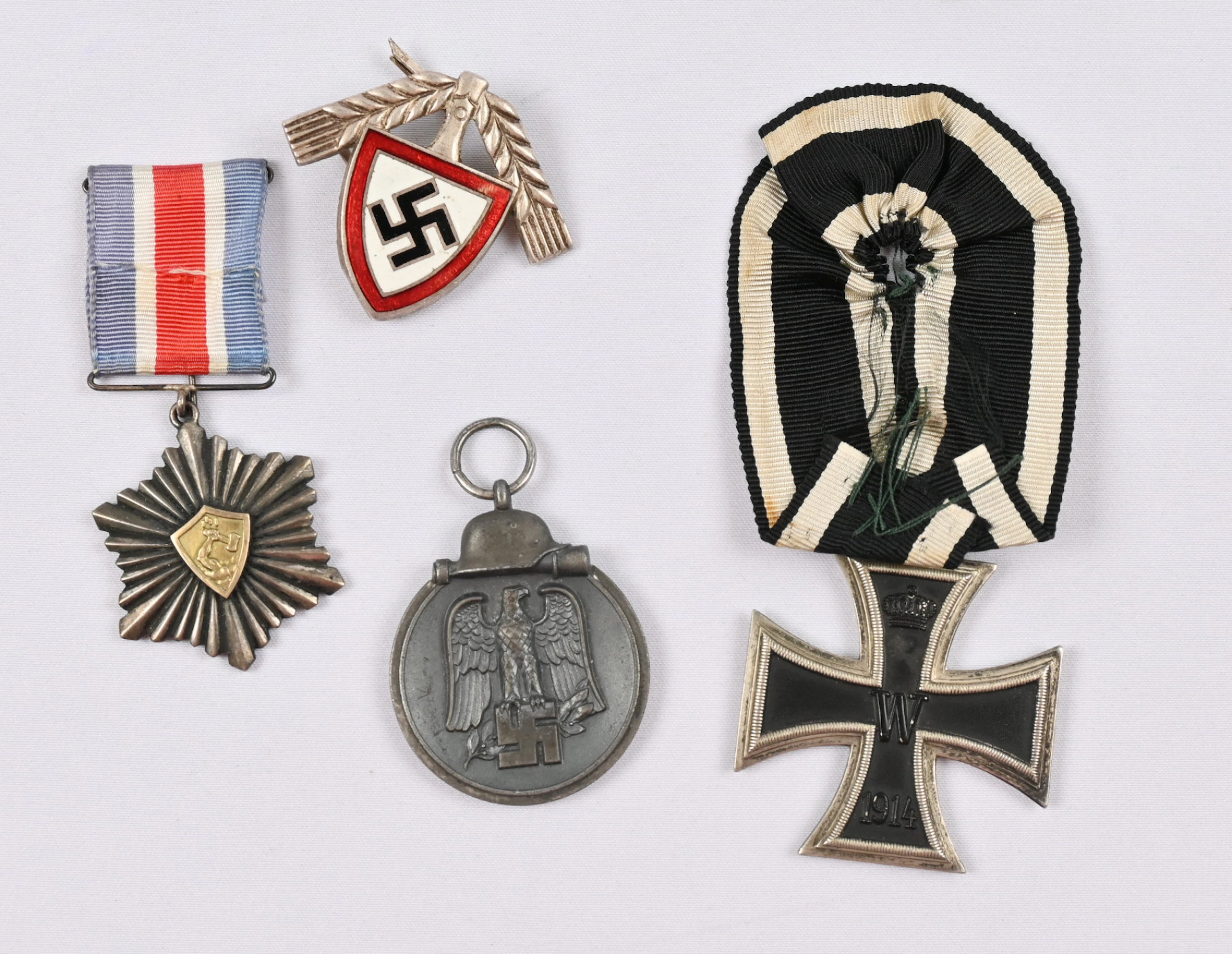 Selection of merit badges, one medal and a German cap badge. On the