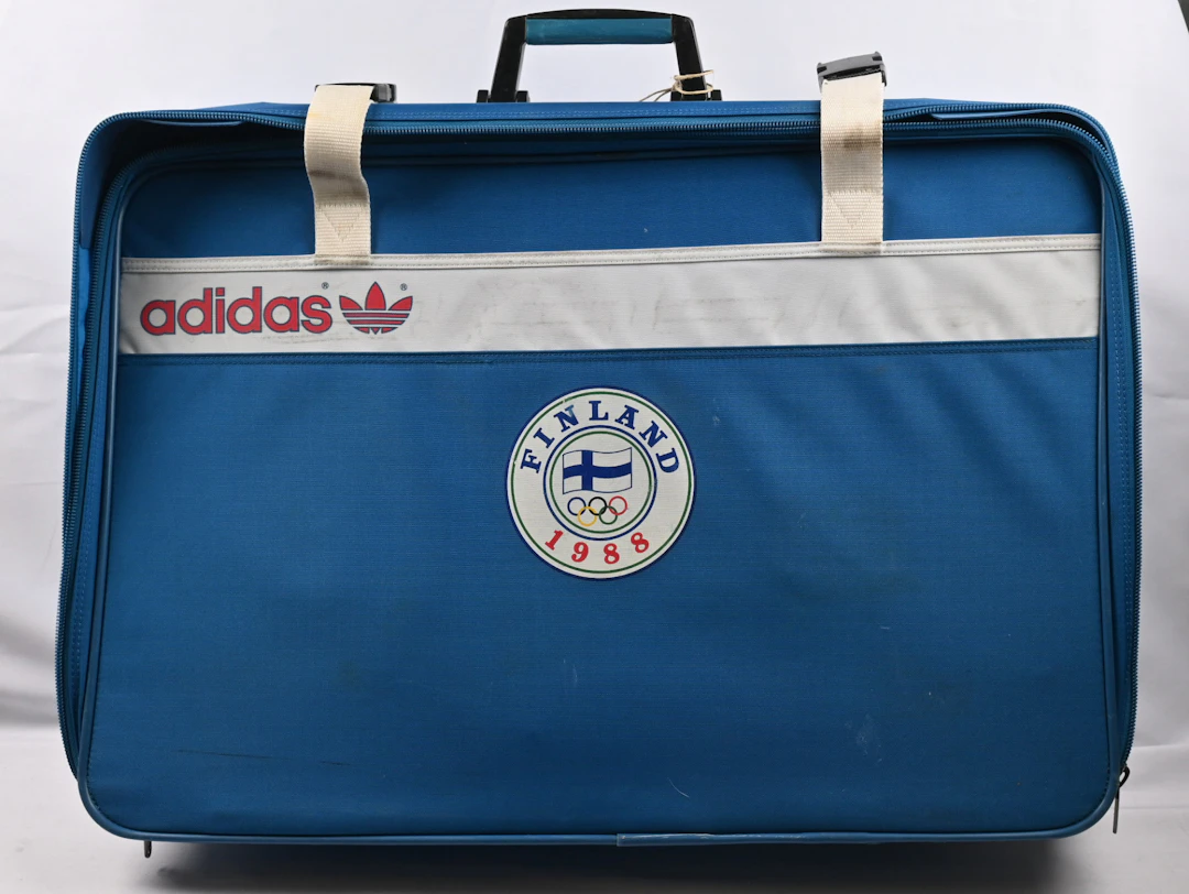 1988 Adidas suitcase, cloth, mascot, and figurine.