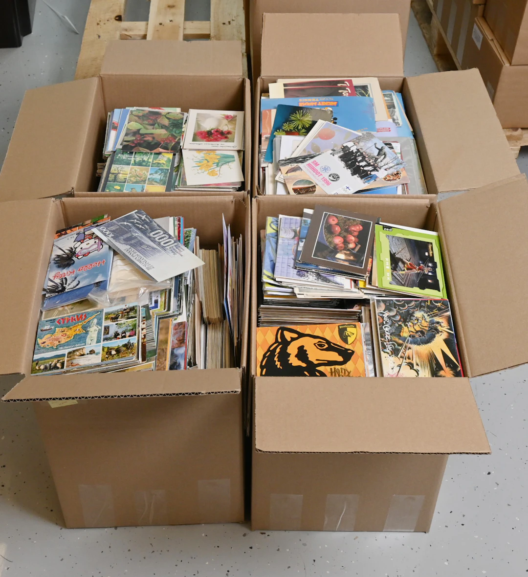 Large stock of unused postcards in four large boxes, in total over