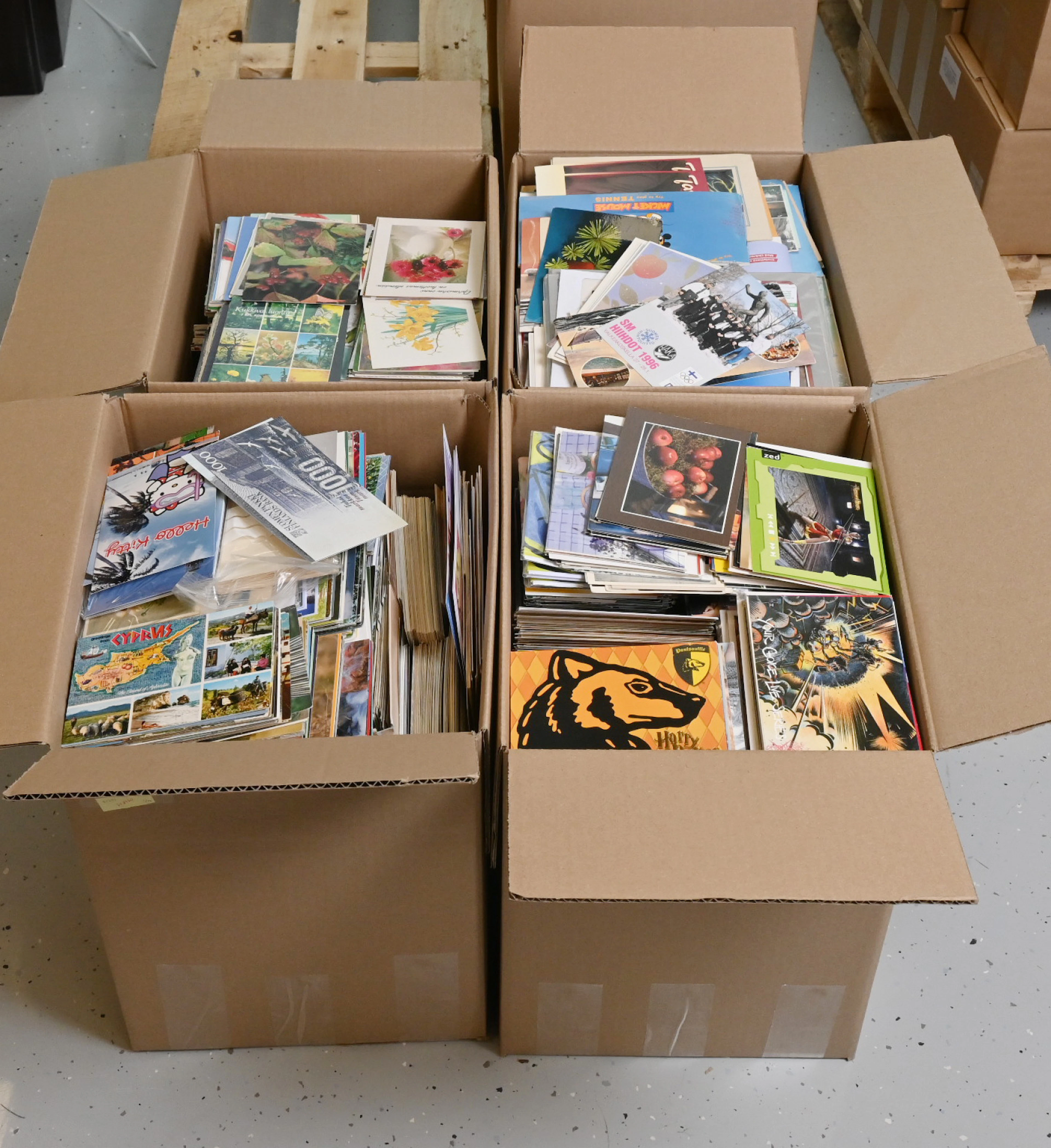 Large stock of unused postcards in four large boxes, in total over