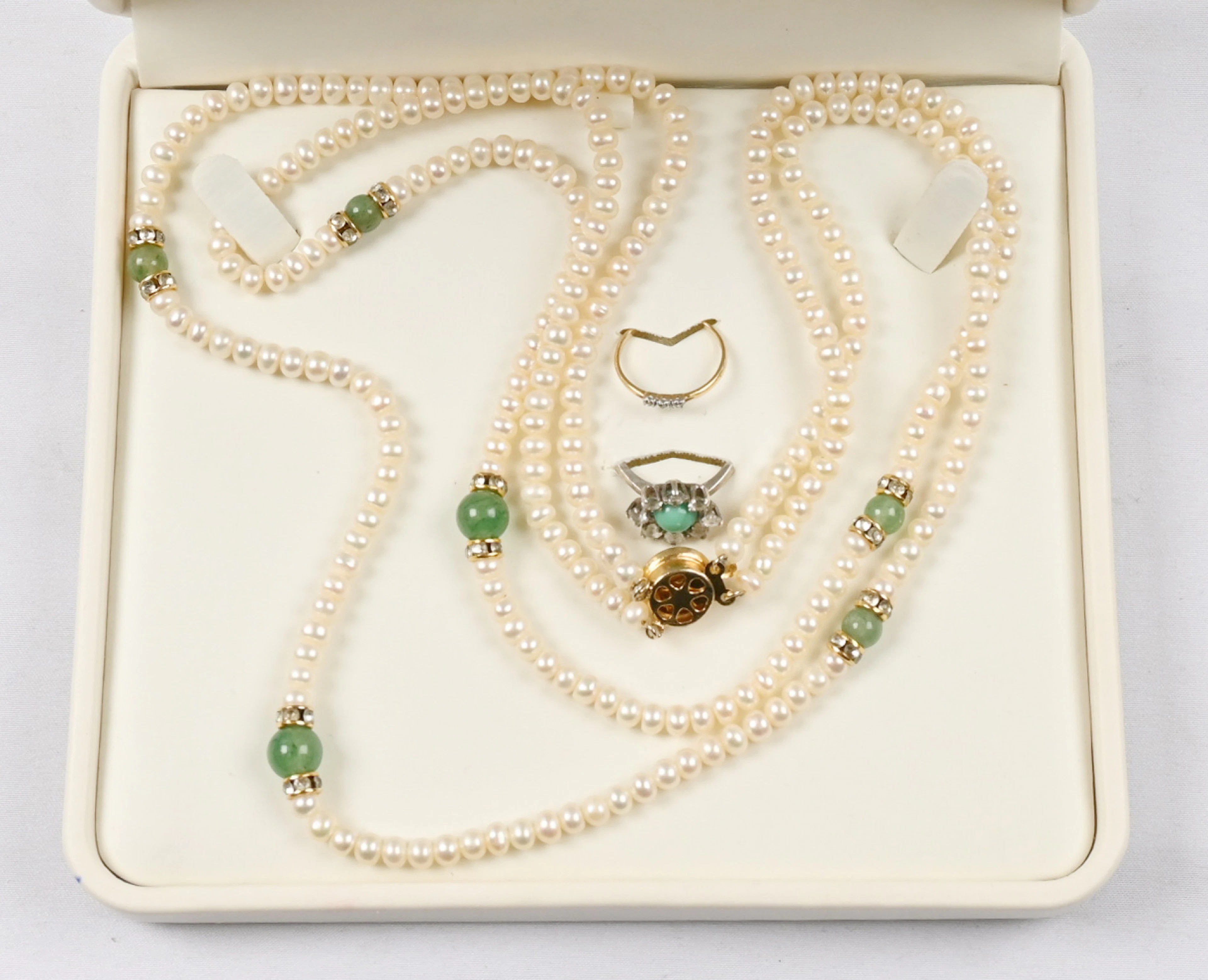 Small selection: pearl necklace with jade, two rings, one of which is gold.