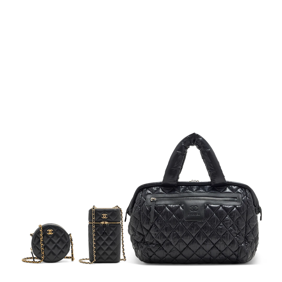 A Set of Three: a Black Nylon Coco Cocoon Travel Bag with Silver Hardware