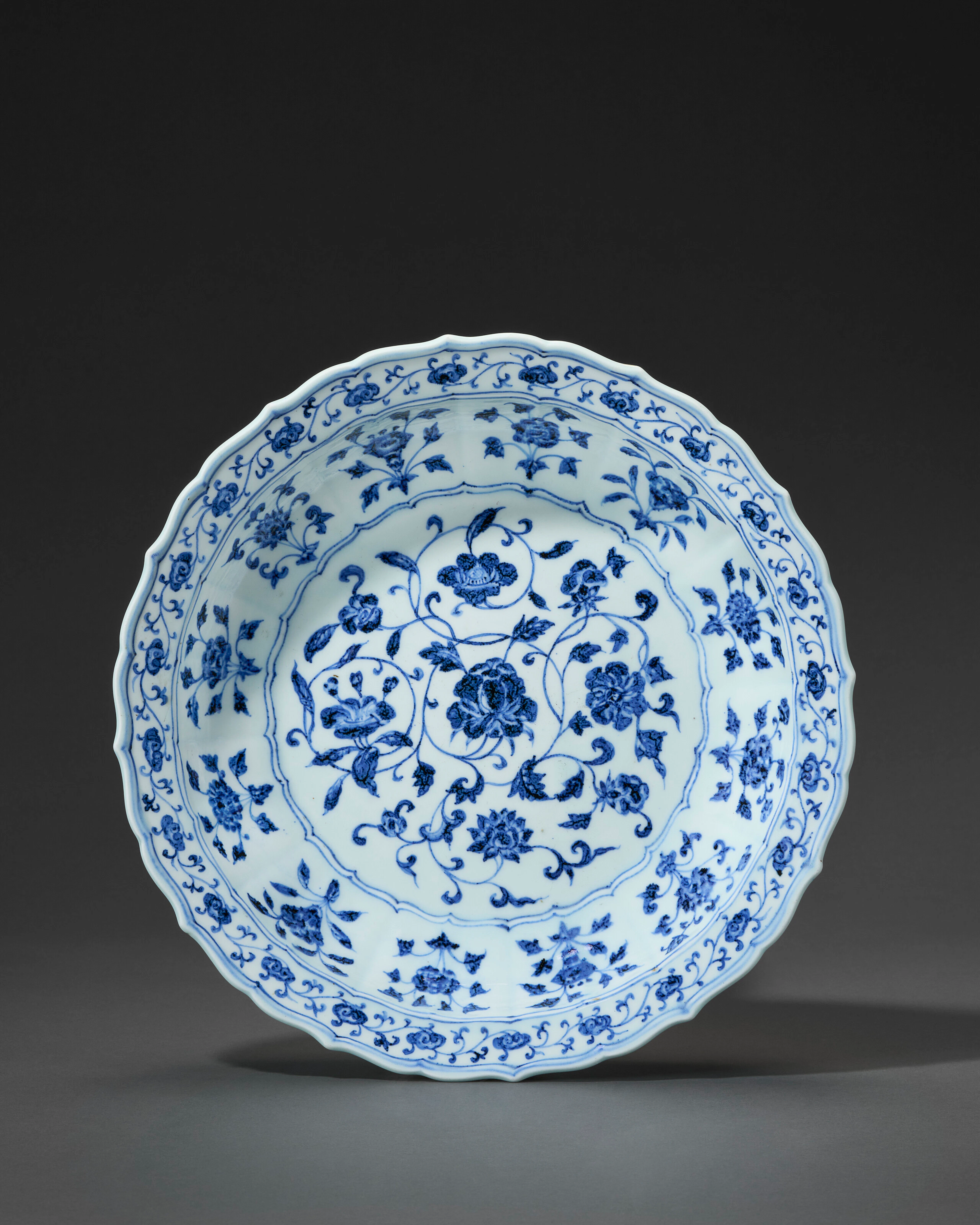 A RARE LARGE BLUE AND WHITE BRACKET-LOBED 'FLORAL SCROLL' DISH