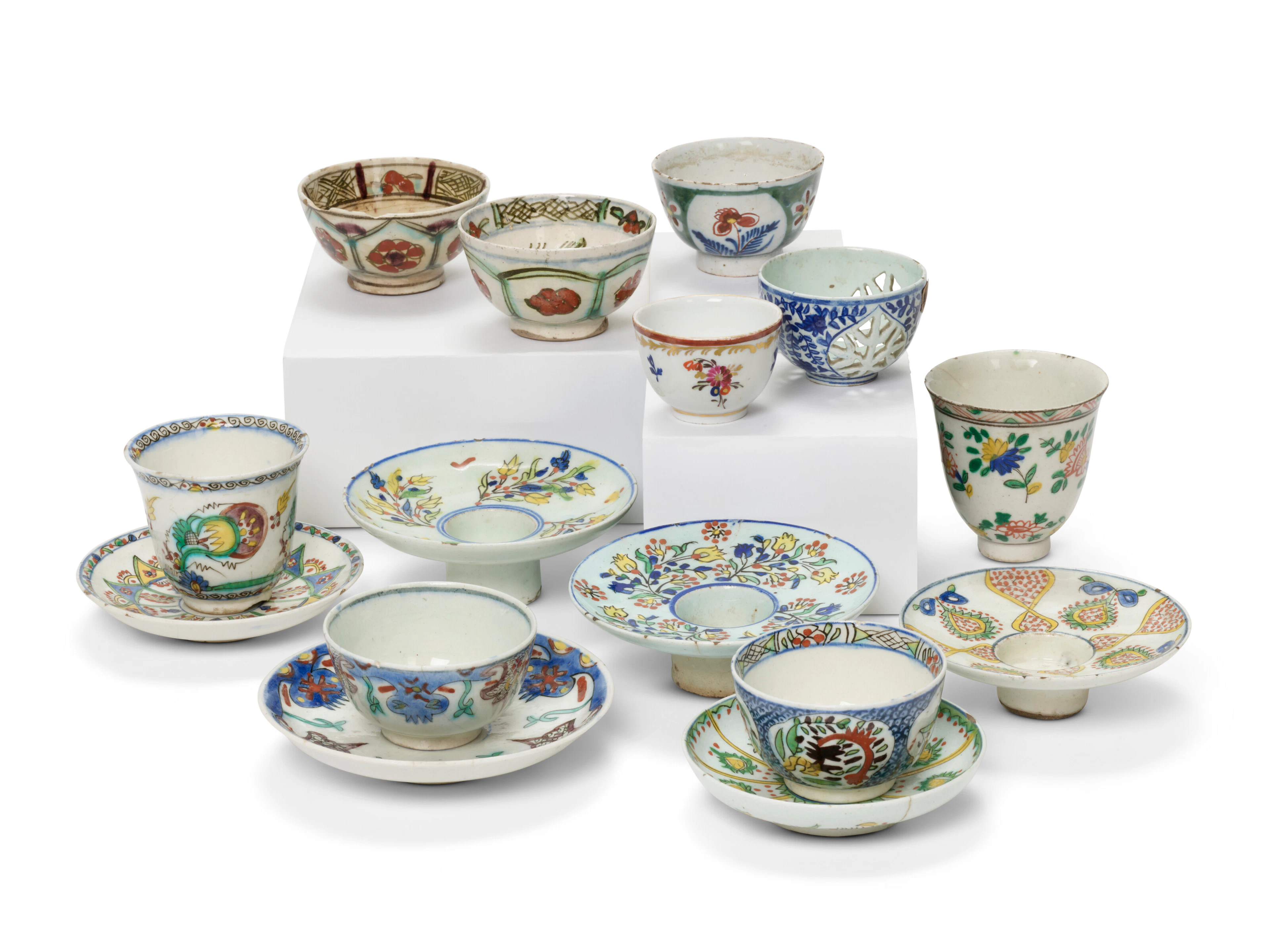 A Group of Kütahya Pottery Cups, Saucers and Candle Holders