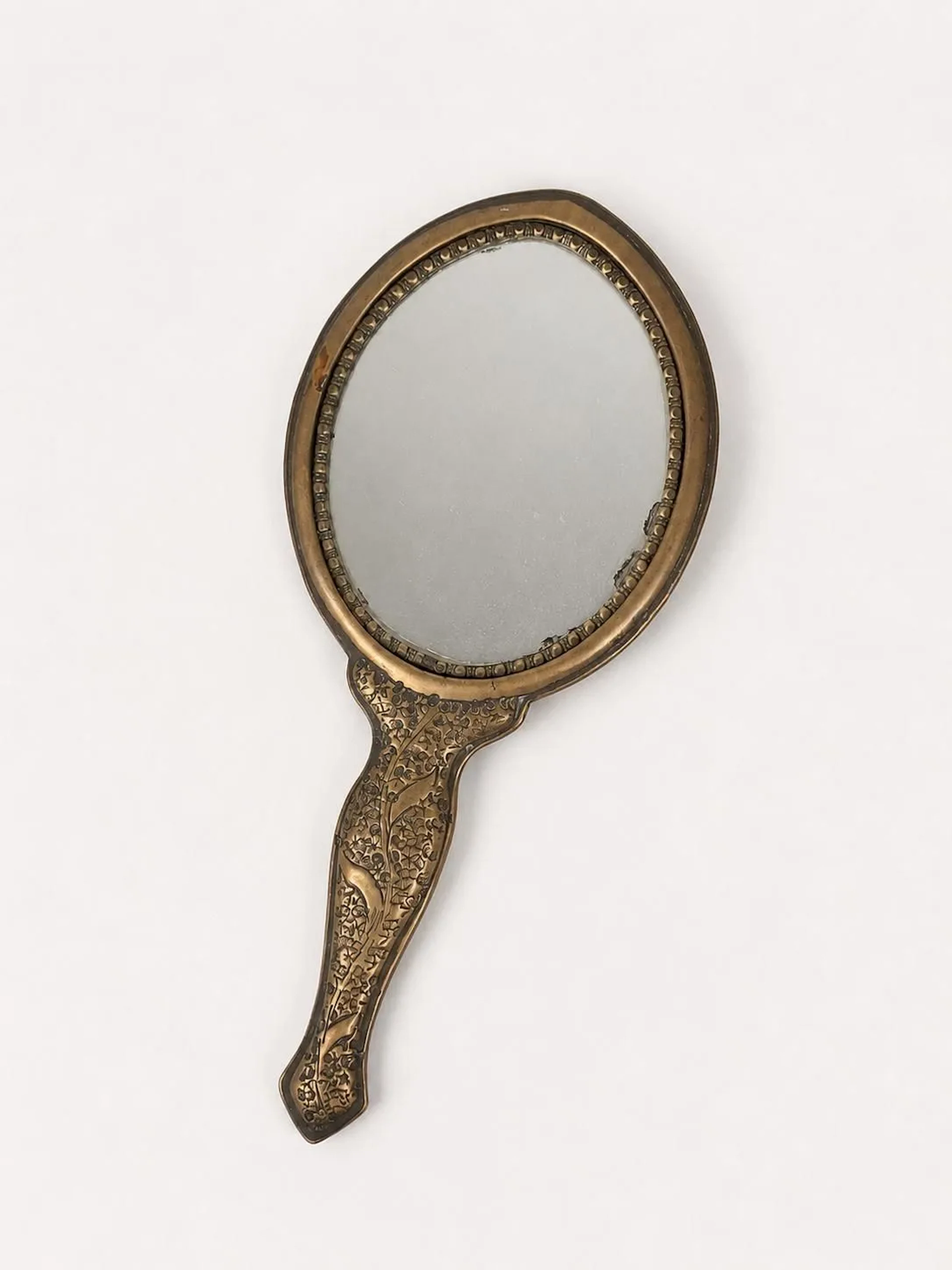 Brass hand mirror with a design of stems and flowers - Lot 172