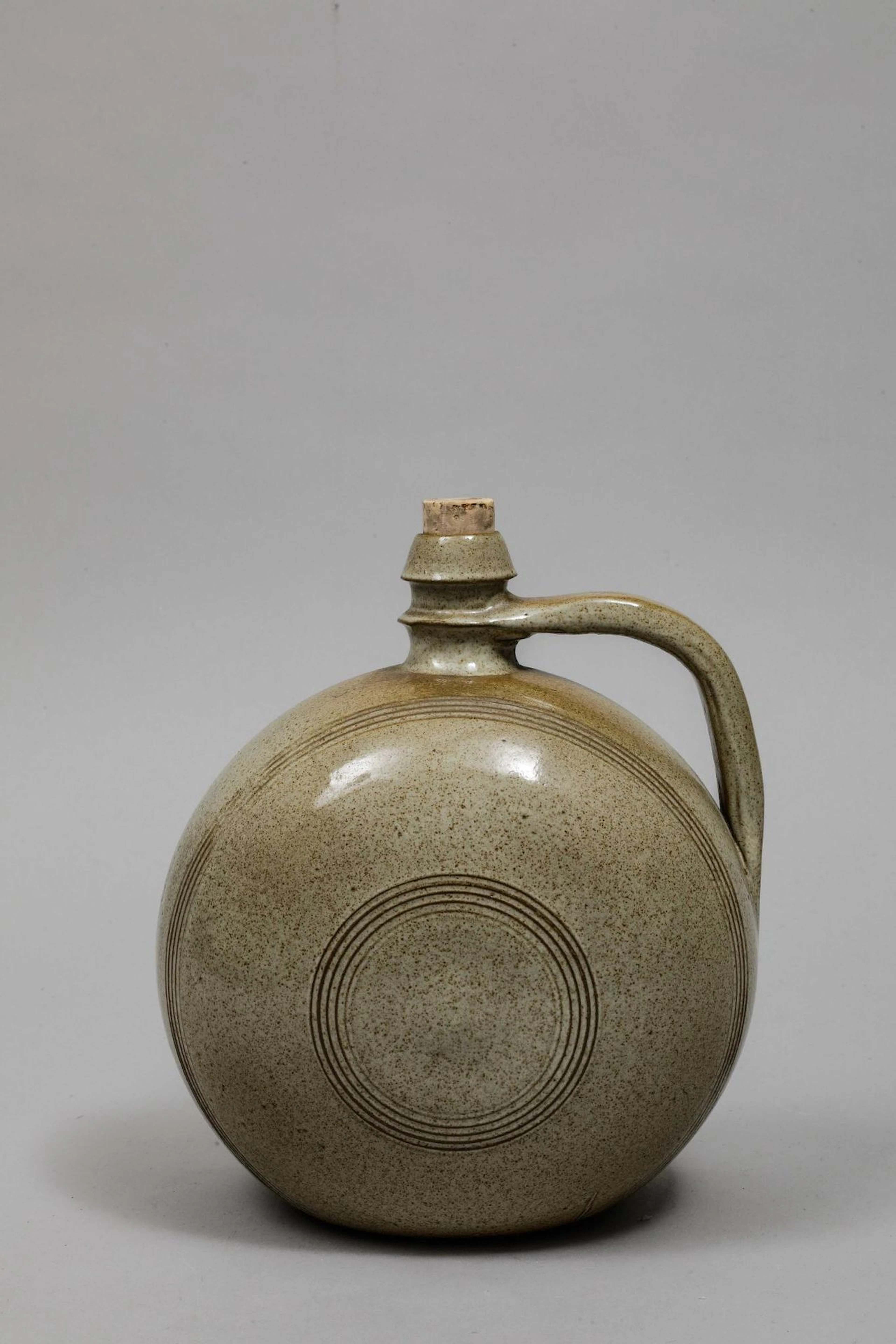 Beige glazed ceramic flask with handle, one convex side and - Lot 62