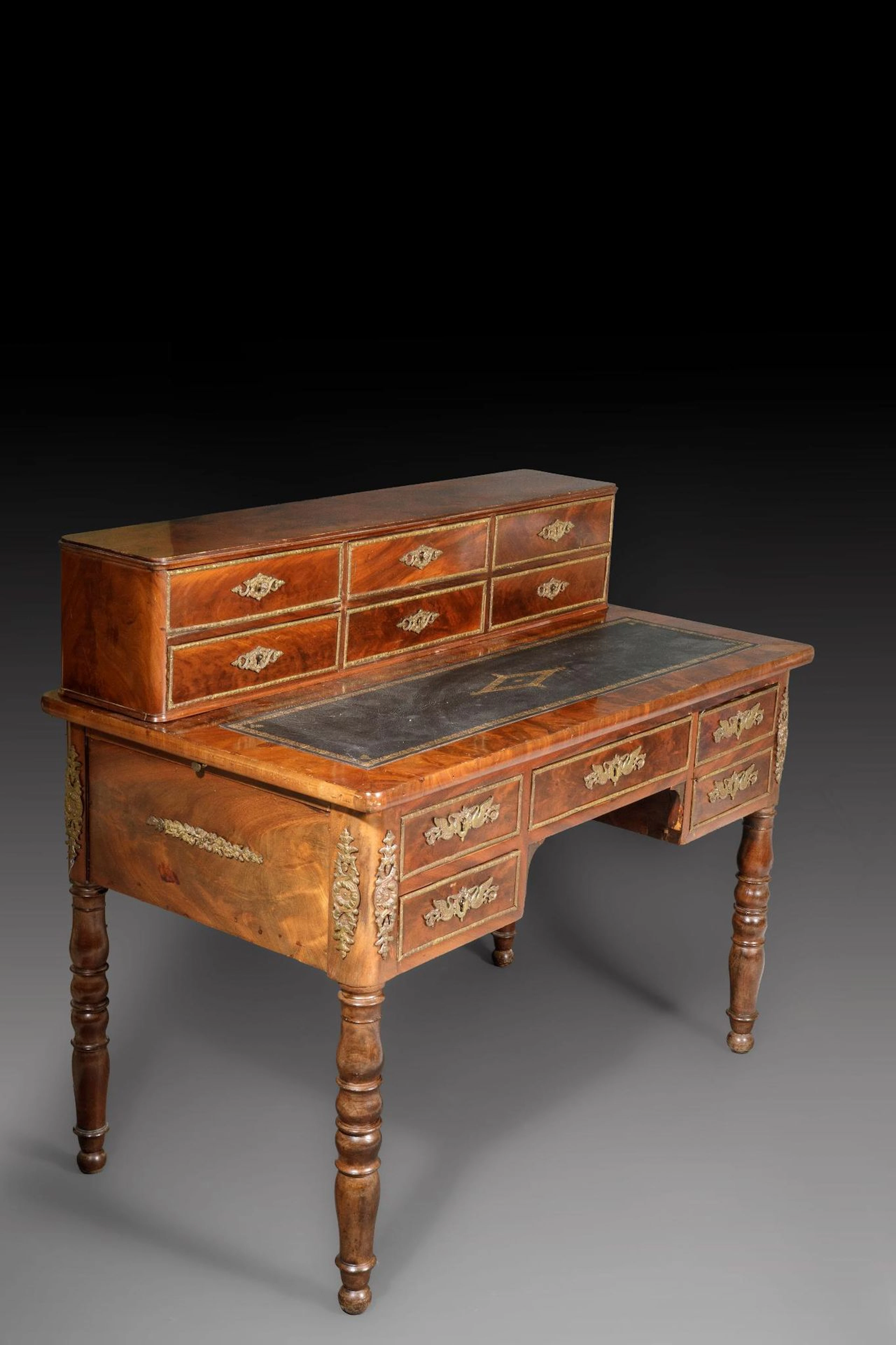 A stepped desk made of mahogany and mahogany veneer, with a - Lot 180