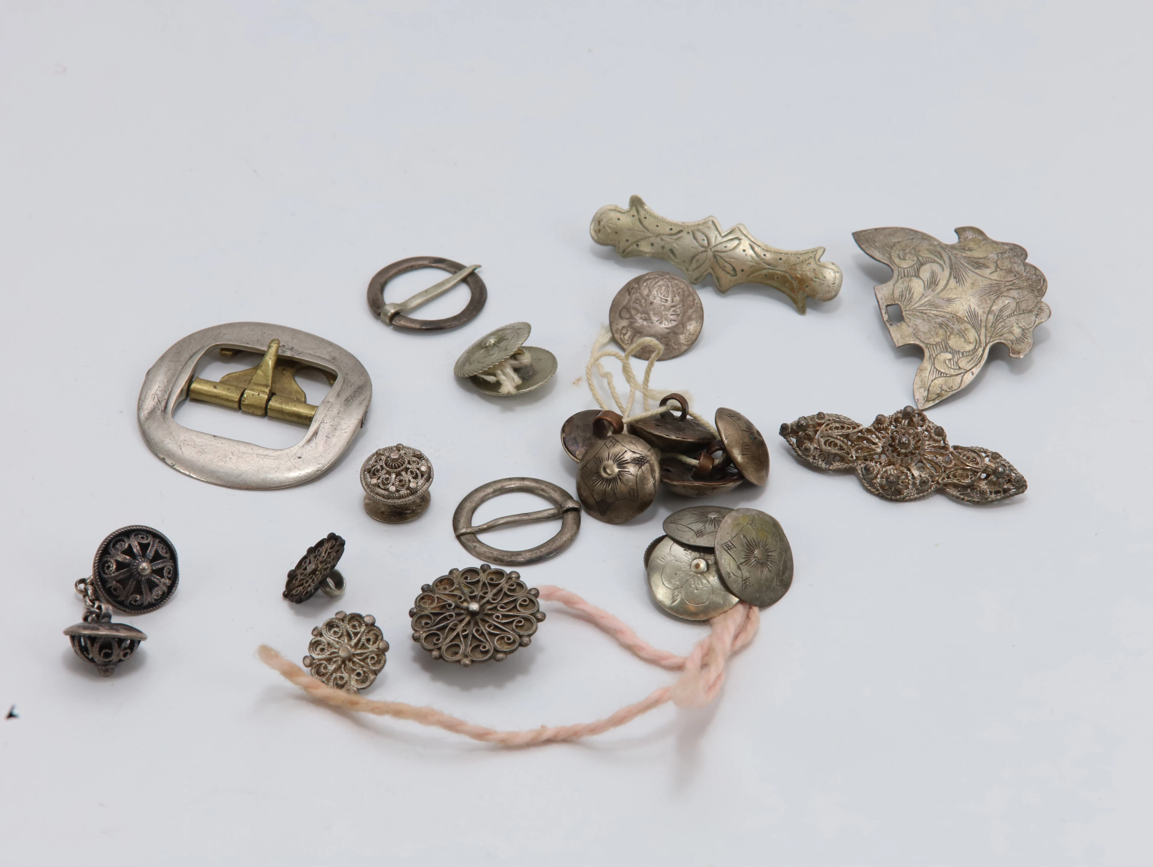 Samling eldre bunadssølv og metallarbeider – knapper, spenner og beslag