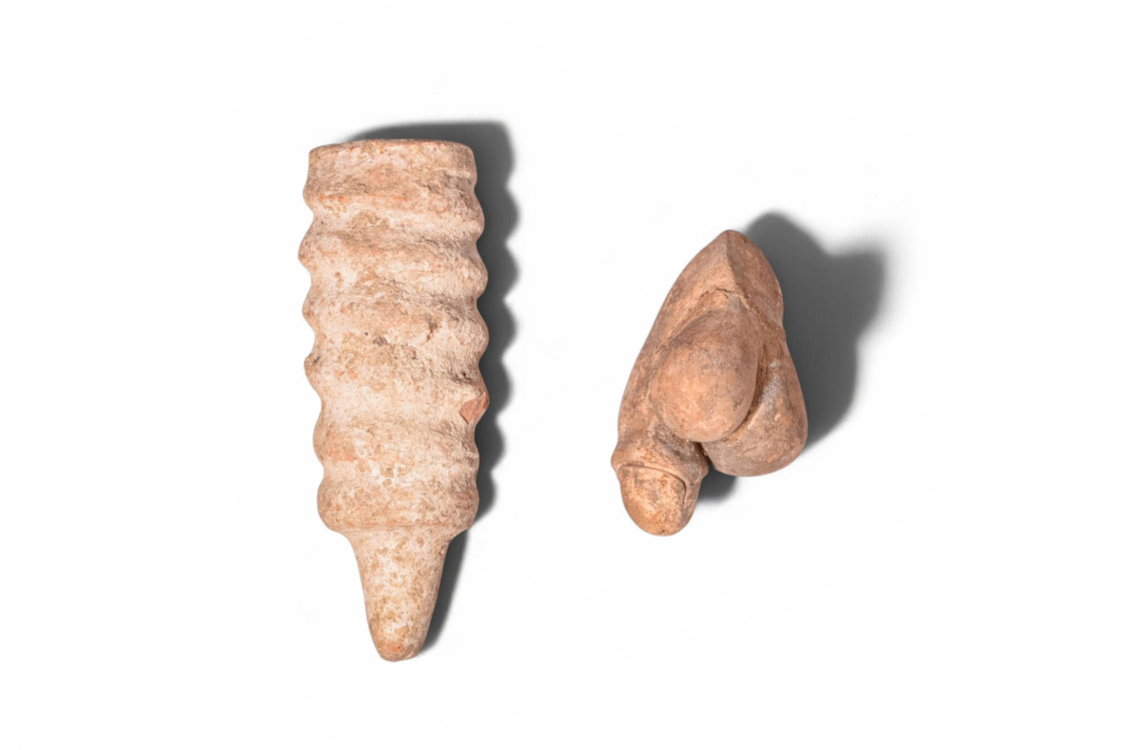 PAIR OF ETRUSCAN AND ROMAN STONE AND TERRACOTTA PHALLIC AMULETS