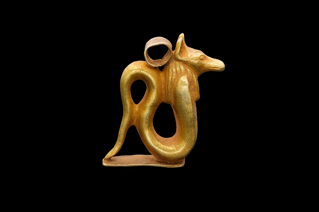 RARE EGYPTIAN GOLD PENDANT IN THE FORM OF A JACKAL-HEADED COBRA