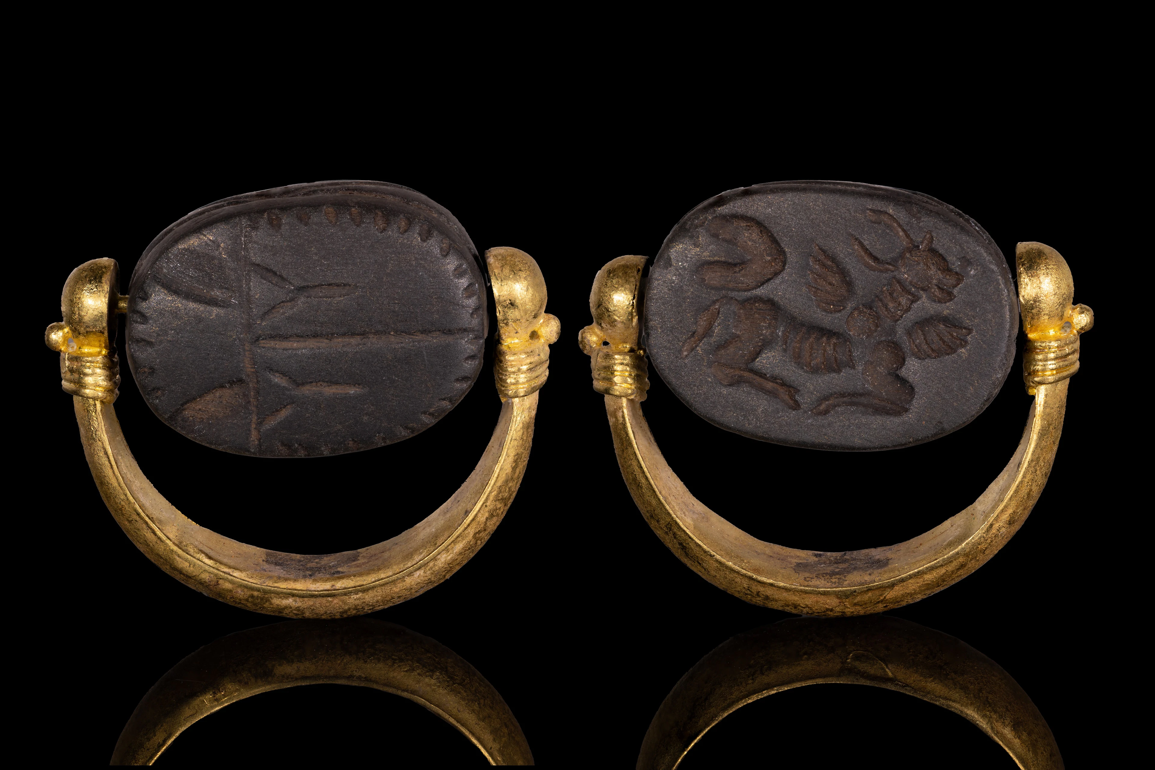 PHOENICIAN BLACK STONE SCARABOID WITH WINGED BULL IN GOLD SWIVEL RING