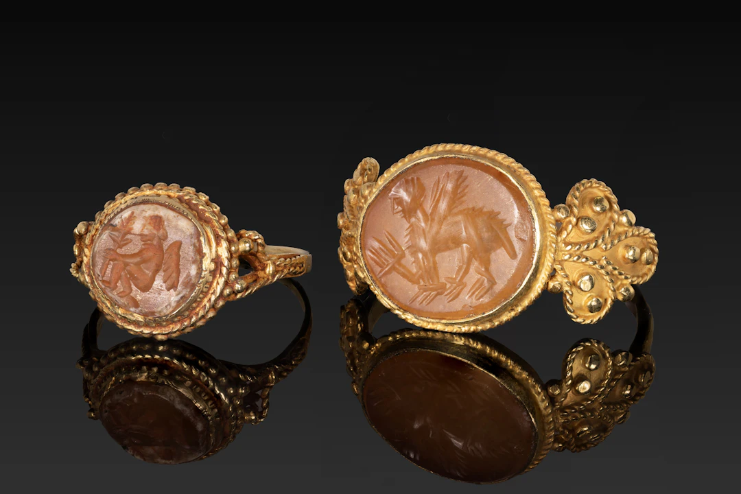 SASSANIAN CARNELIAN INTAGLIOS OF EROS AND A SPHINX IN GOLD RINGS