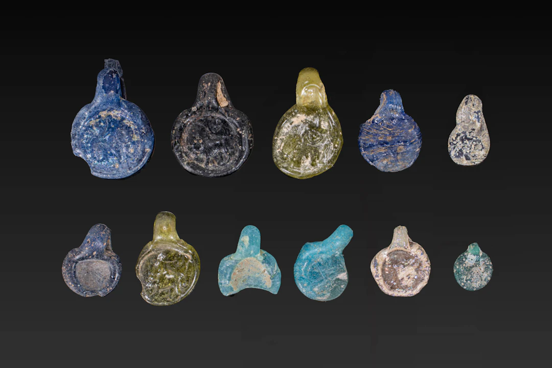 COLLECTION OF ROMAN GLASS STAMPED PENDANTS