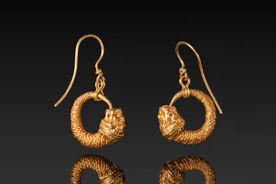 MATCHED PAIR OF HELLENISTIC HIGH KARAT GOLD LION-HEAD EARRINGS