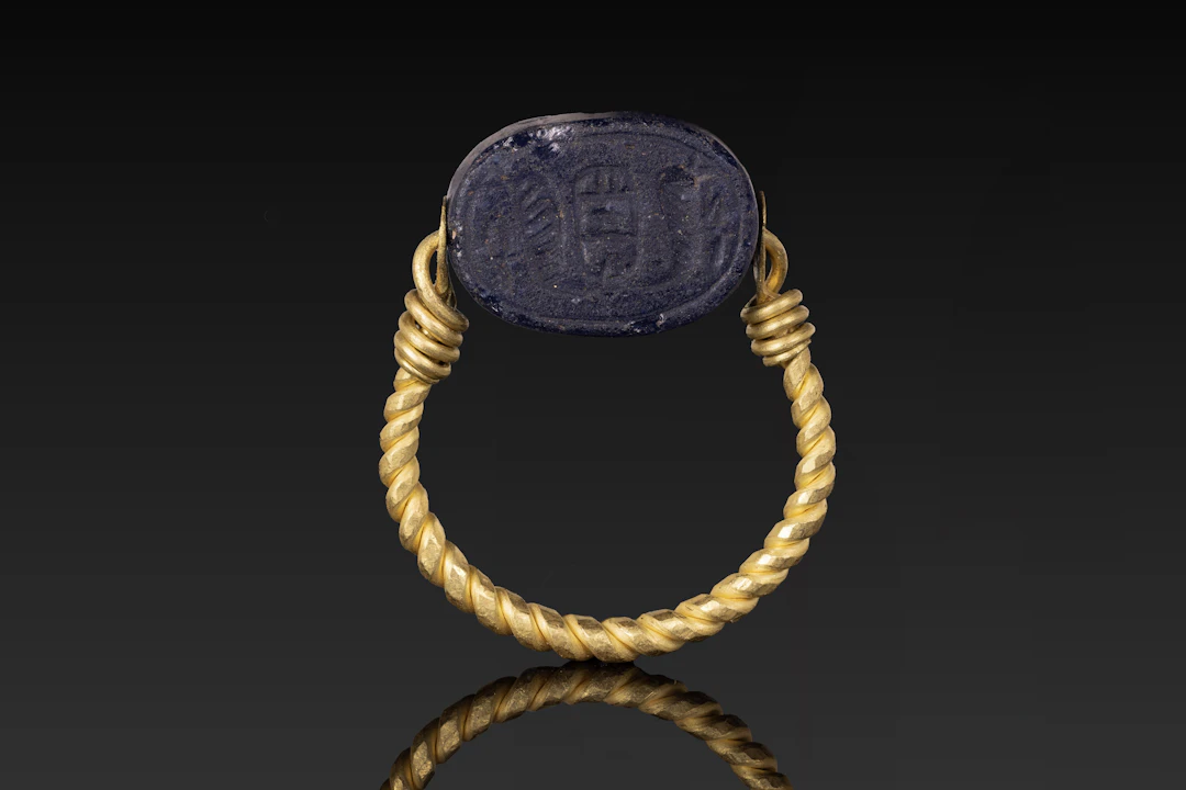 PHOENICIAN GLASS SCARAB WITH UREAUS AND PSEUDO CARTOUCHE IN GOLD SWIVEL RING