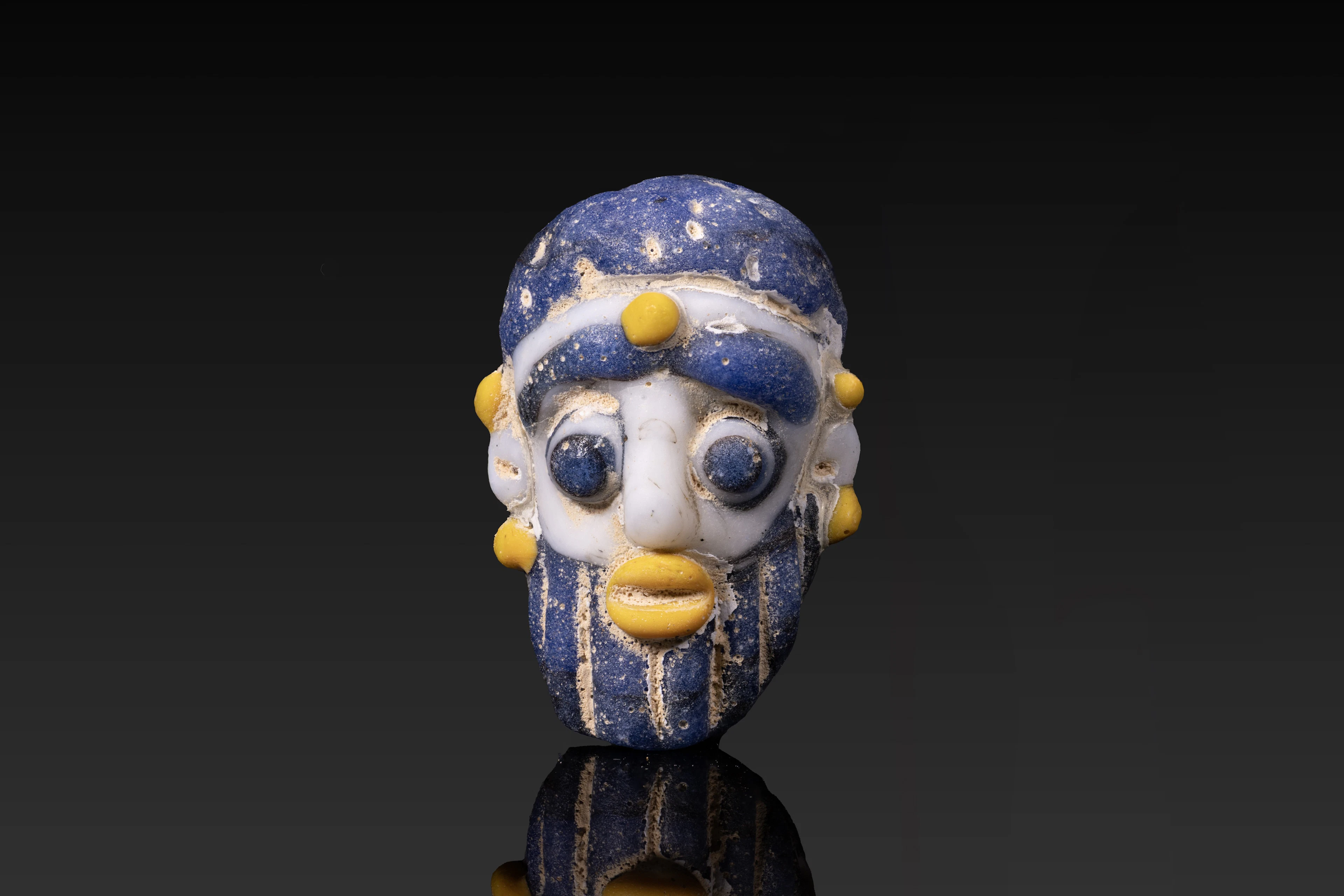 PHOENICIAN POLYCHROME GLASS FACE BEAD