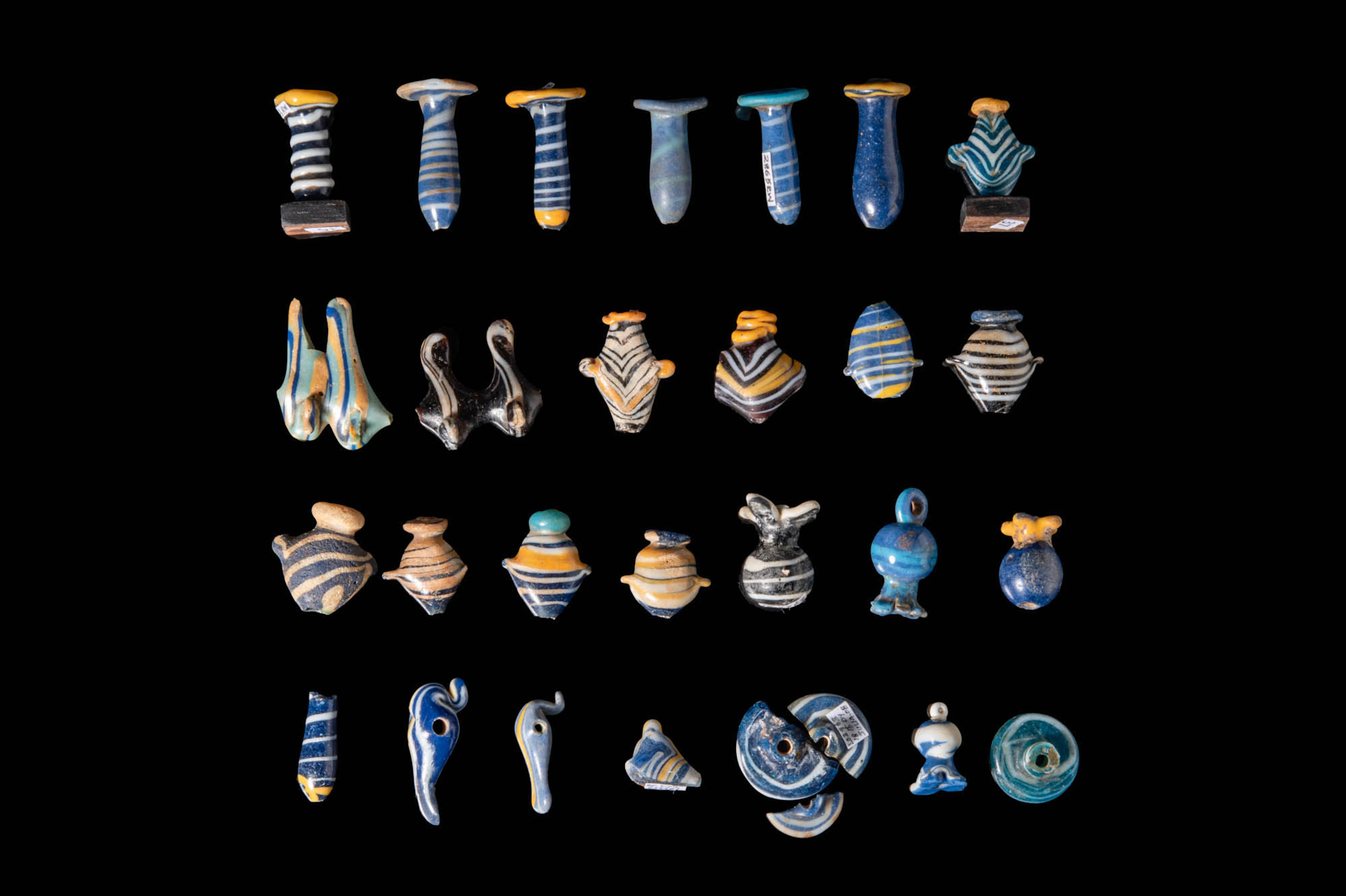 COLLECTION OF EGYPTIAN GLASS AMULETS AND EAR STUDS
