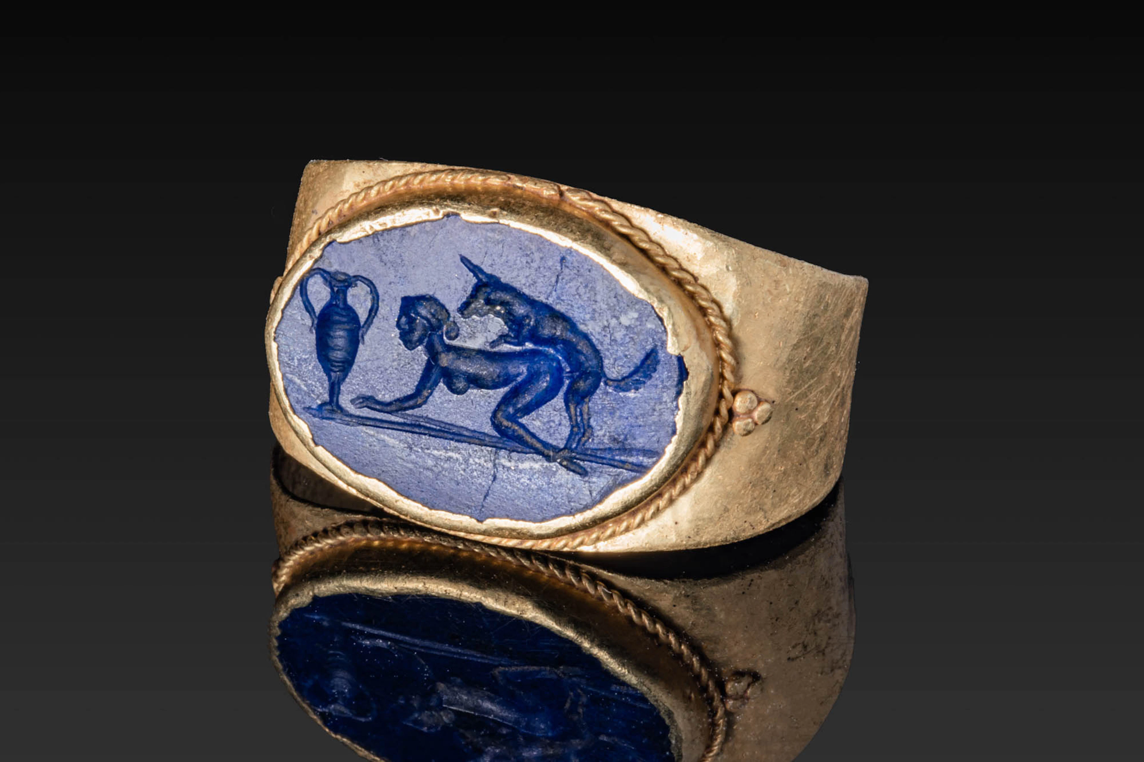 ROMAN OR LATER LAPIS LAZULI INTAGLIO WITH EROTIC SCENE AND AMPHORA