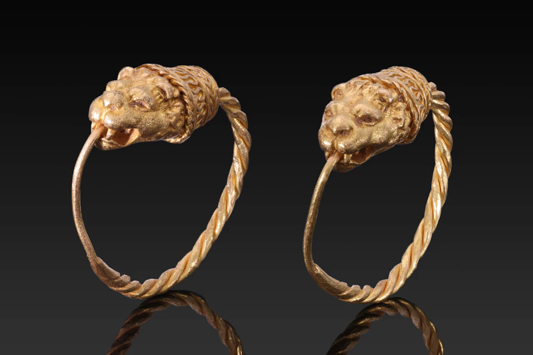 MATCHED PAIR OF HELLENISTIC GOLD EARRINGS WITH EROS HEADS