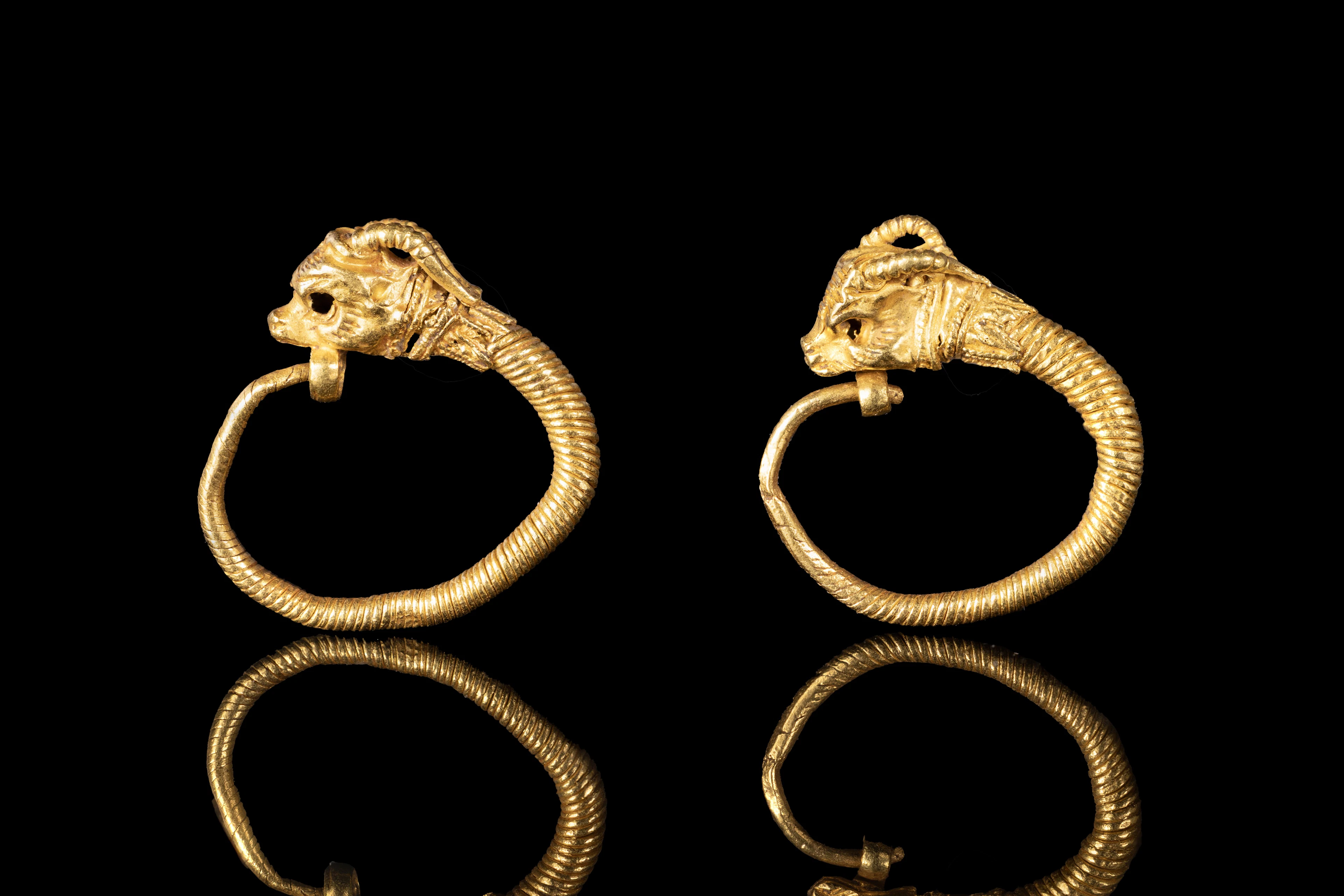 MATCHED PAIR OF GREEK TWISTED GOLD EARRINGS WITH IBEX HEADS