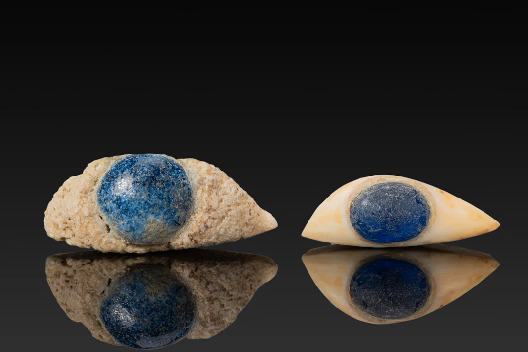 PAIR OF EGYPTIAN STONE AND GLASS EYE INLAYS FROM A MUMMY MASK