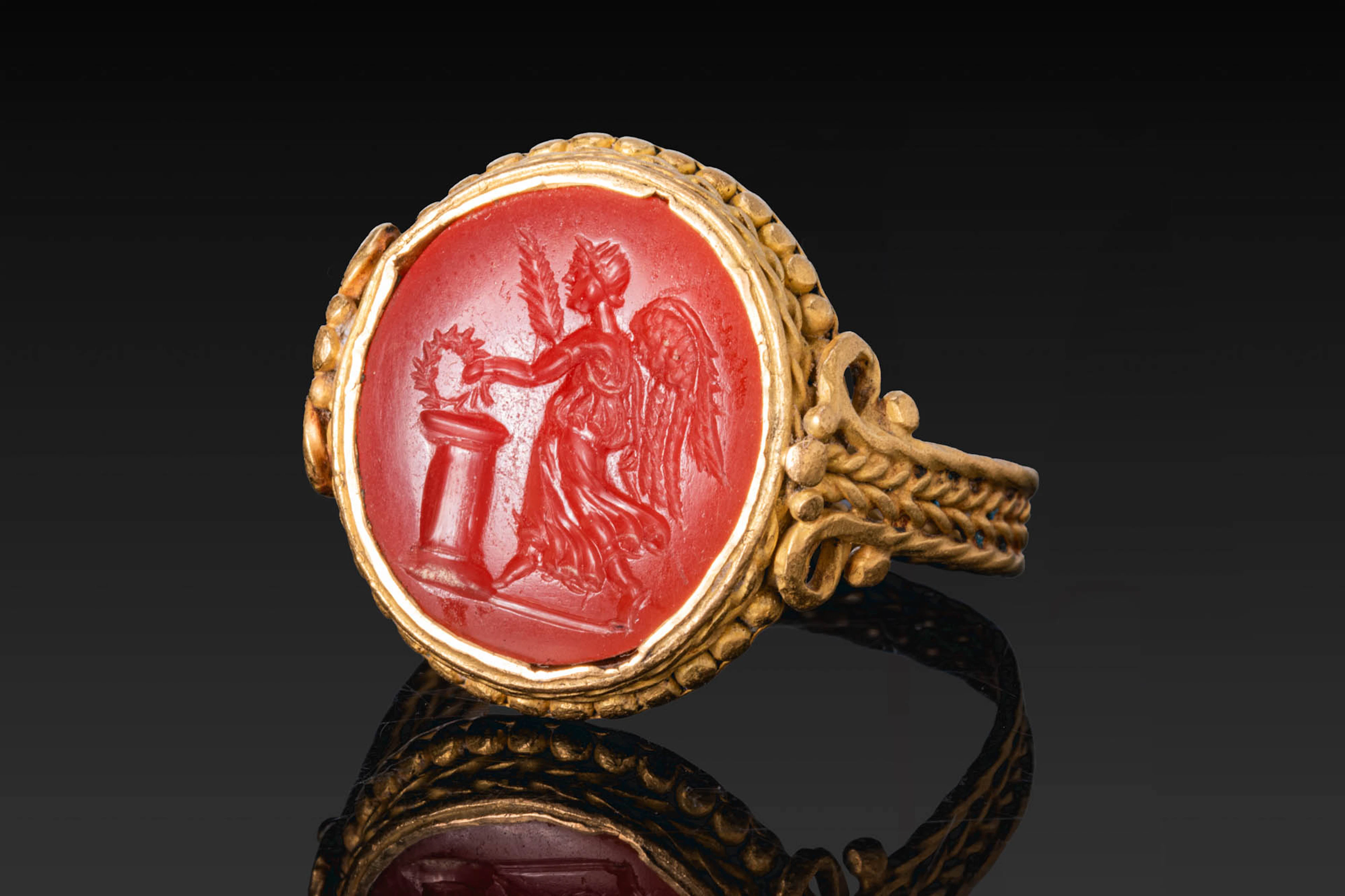 ROMAN CARNELIAN INTAGLIO OF WINGED VICTORY BEFORE AN ALTAR IN GOLD RING
