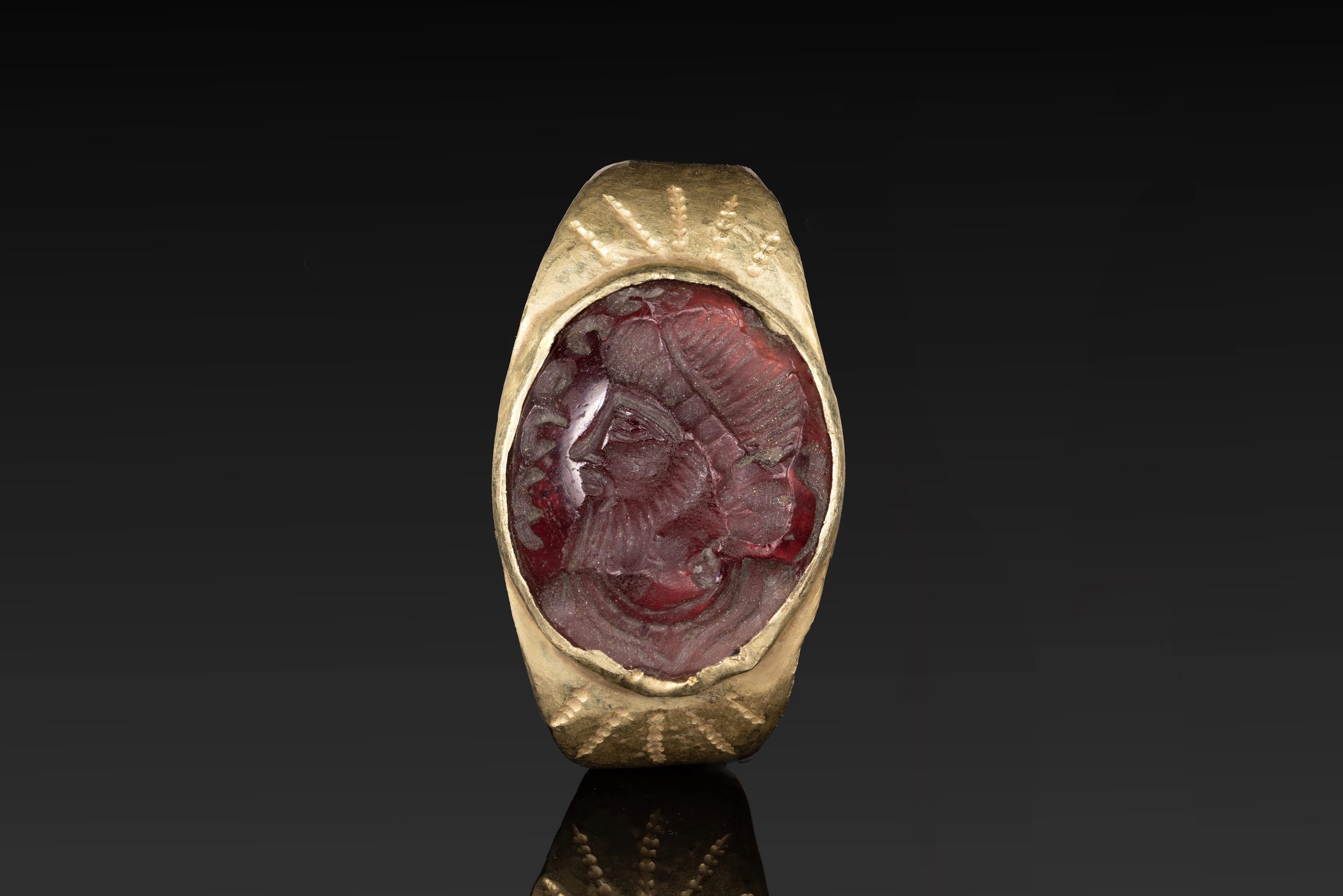 SASANIAN GOLD RING WITH RED GARNET INTAGLIO OF A KING AND INSCRIPTION