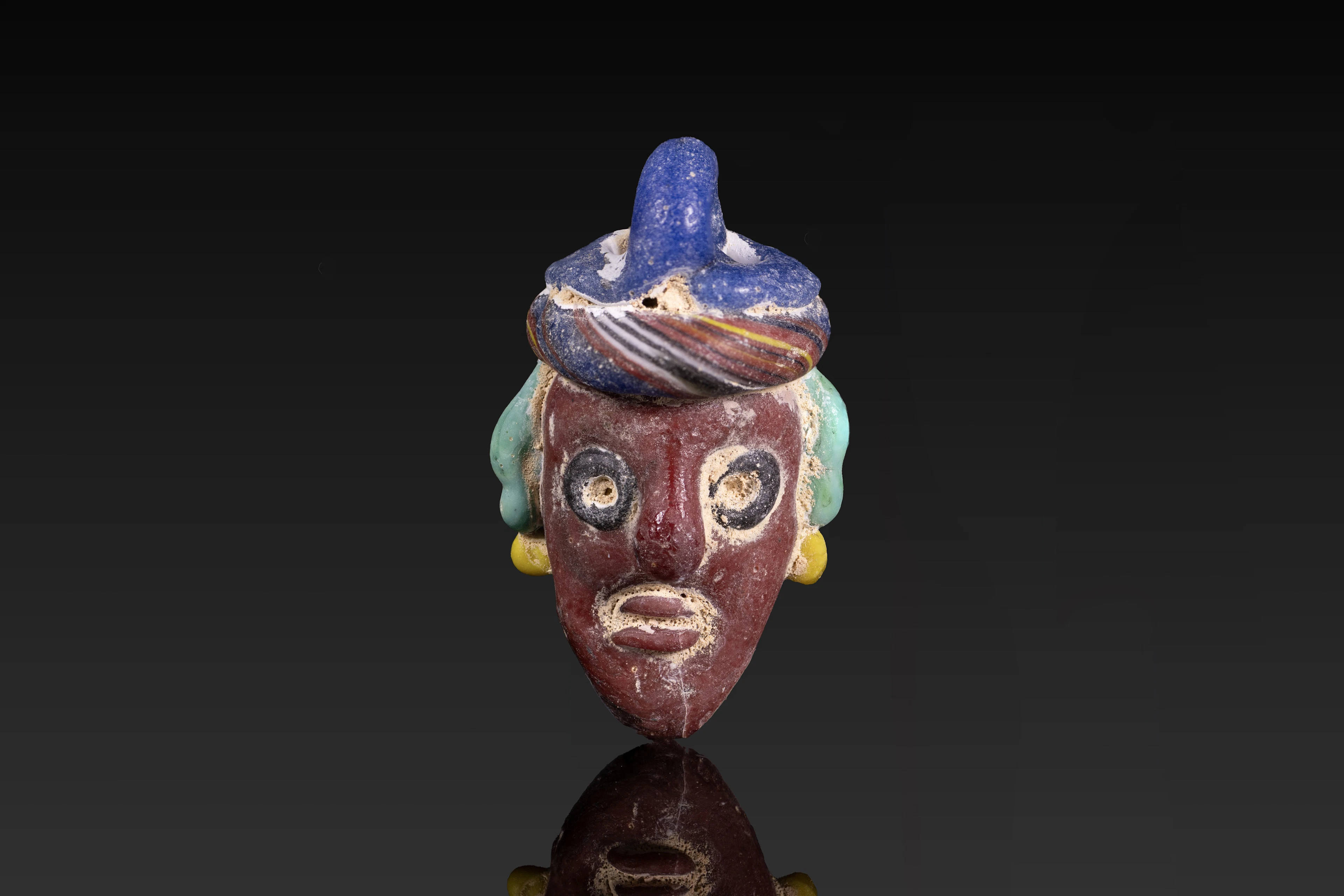 PHOENICIAN POLYCHROME GLASS FACE PENDANT