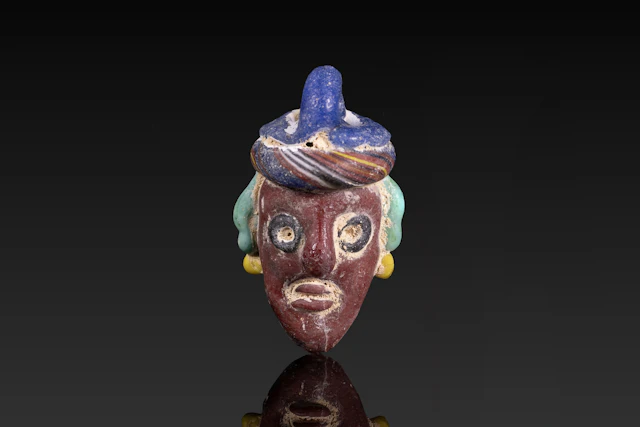 PHOENICIAN POLYCHROME GLASS FACE PENDANT