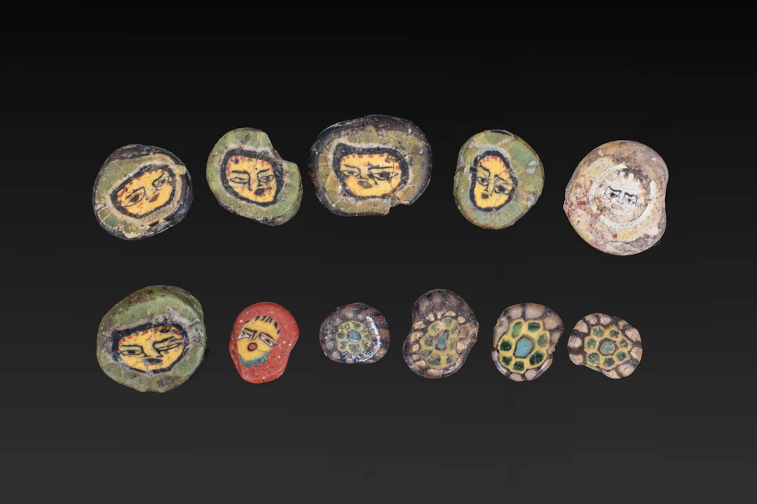 COLLECTION OF ROMAN MOSAIC GLASS BEADS WITH FACES AND FLOWERS