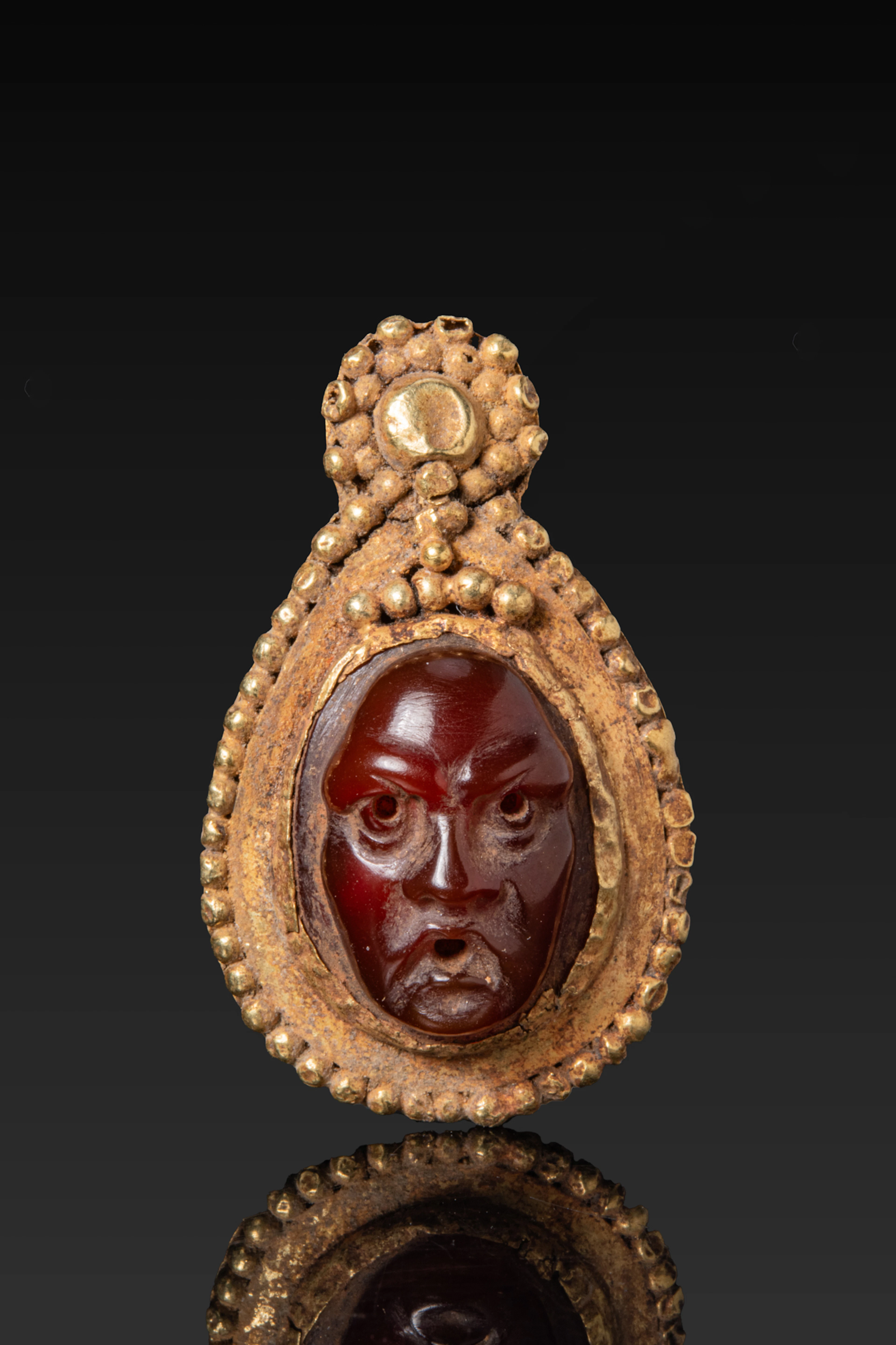 ROMAN HIGH KARAT GOLD DROP-SHAPED PENDANT SET WITH A CARNELIAN HEAD