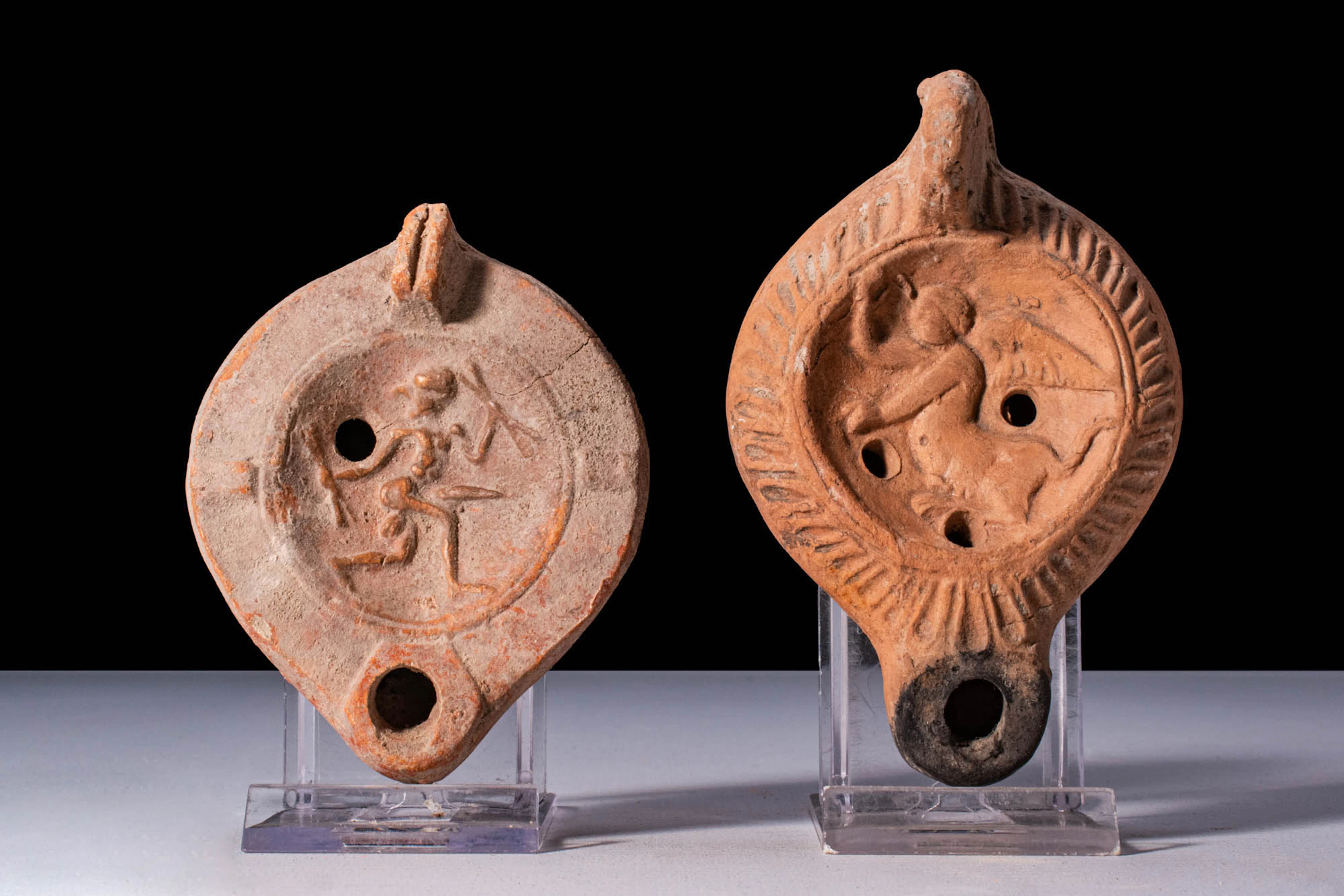 PAIR OF ROMAN TERRACOTTA OIL LAMPS WITH FIGURAL DECORATION