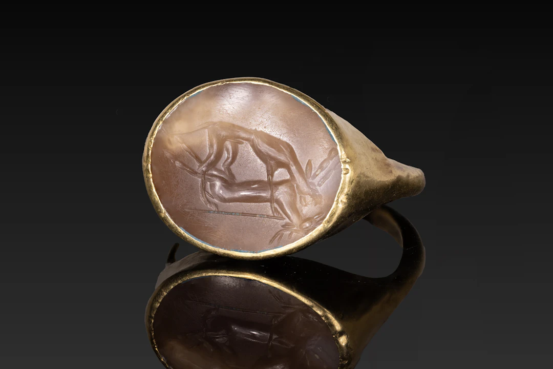 ROMAN GOLD RING WITH AGATE INTAGLIO OF A HOUND AND FALLEN STAG