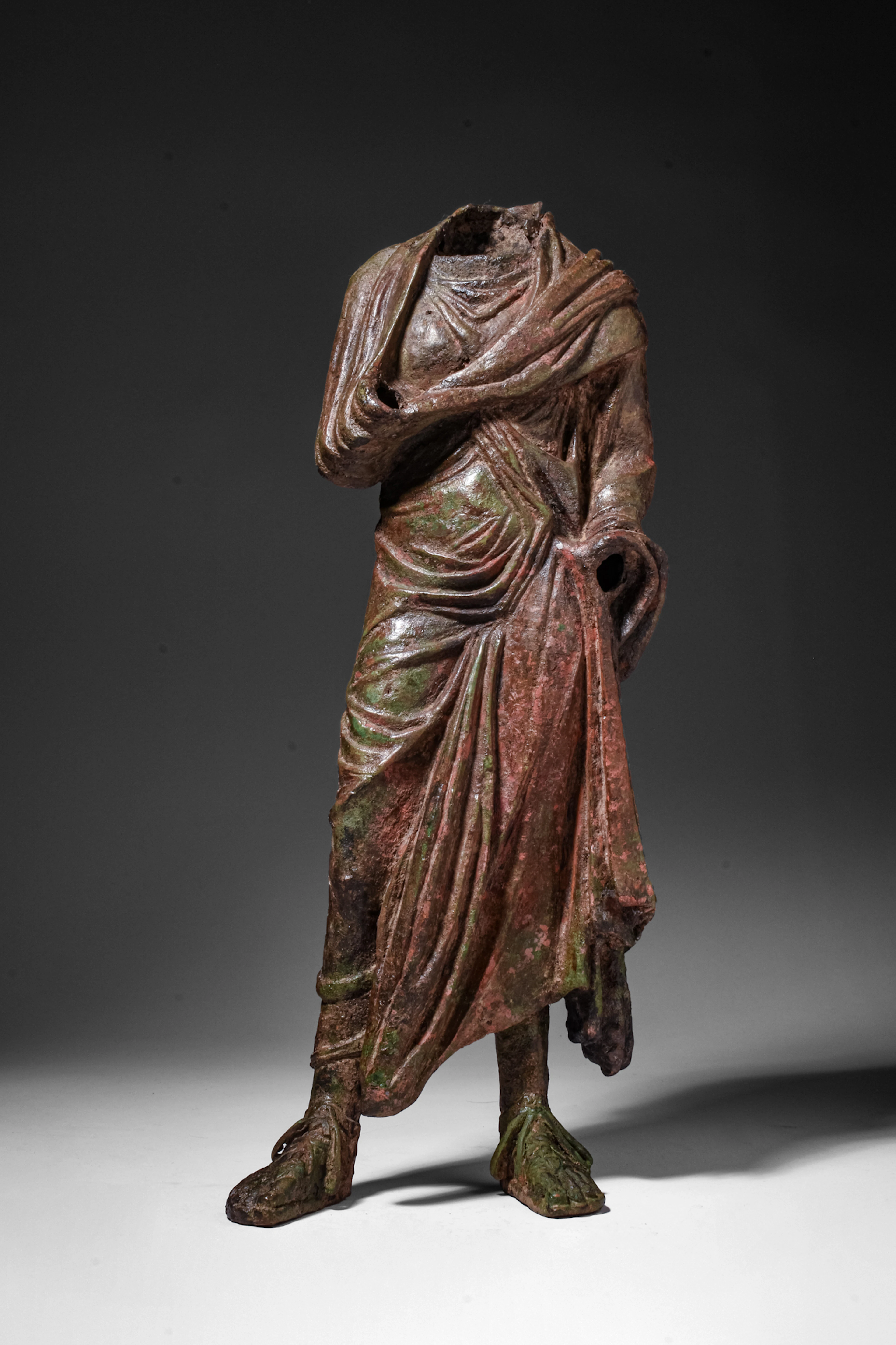 LARGE HELLENISTIC BRONZE STATUETTE OF A DRAPED MALE FIGURE